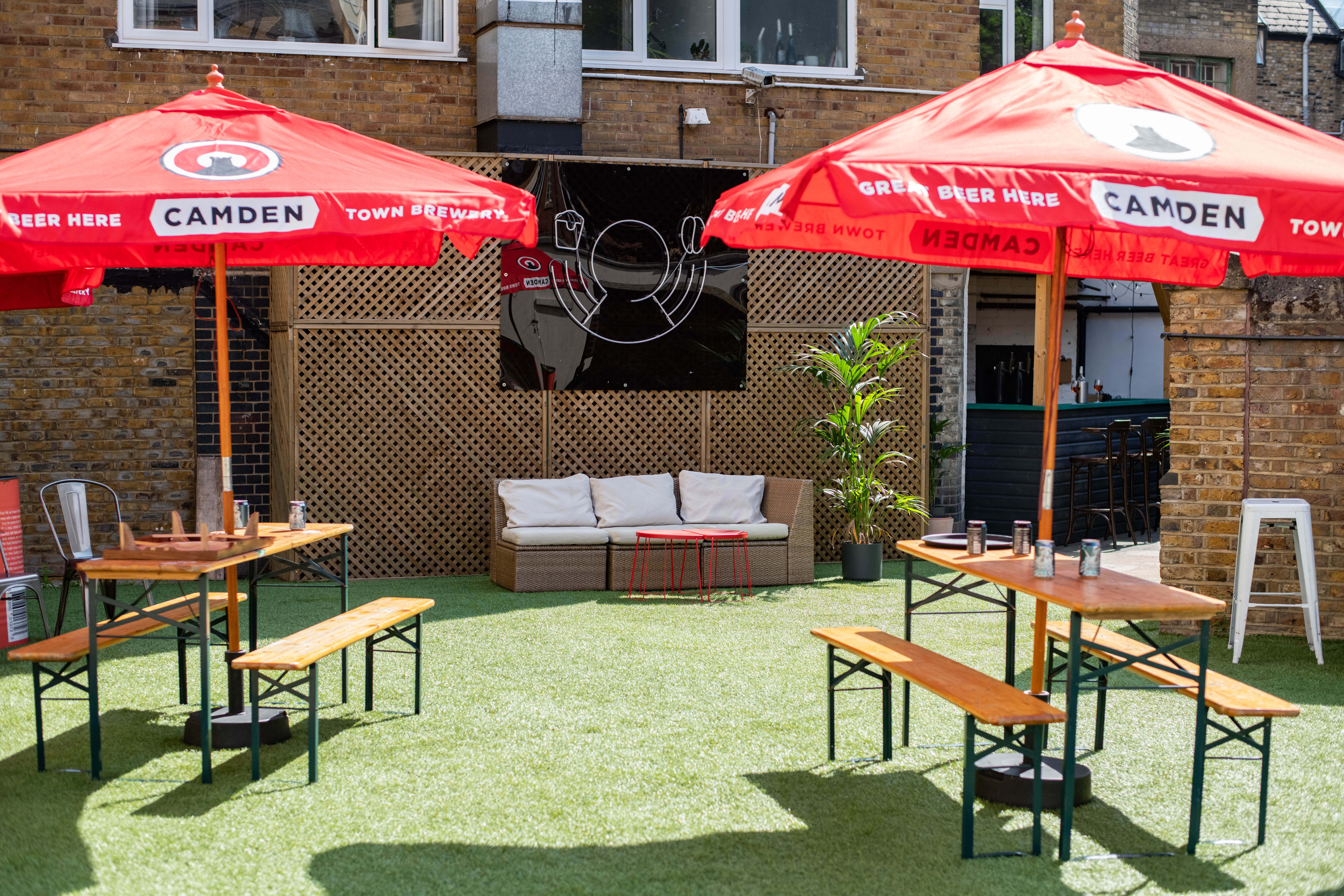 Vibrant outdoor event space with branded umbrellas for summer gatherings in Hackney.
