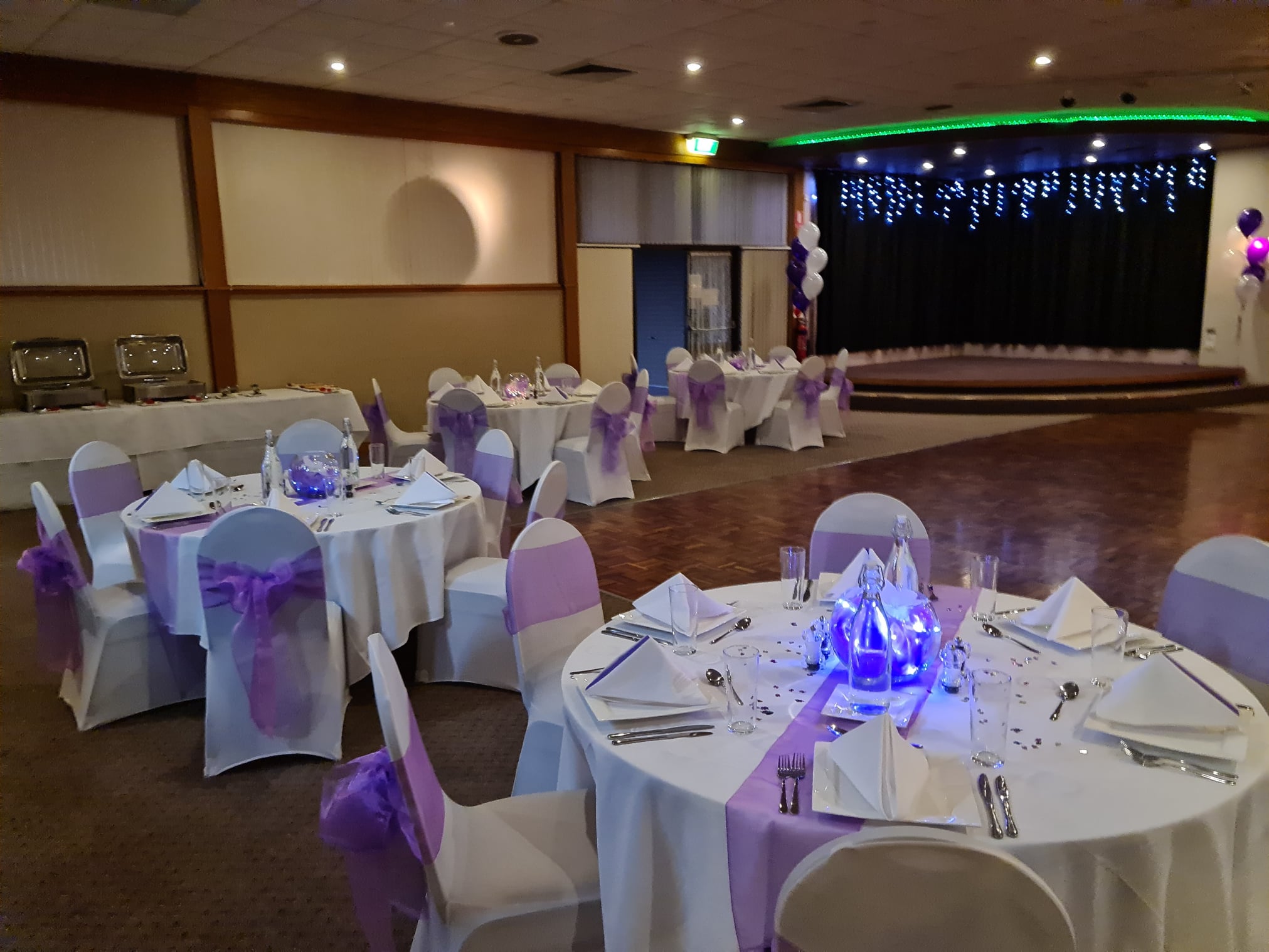 Elegant event space at Austrian Club Canberra with white and purple decor for celebrations.