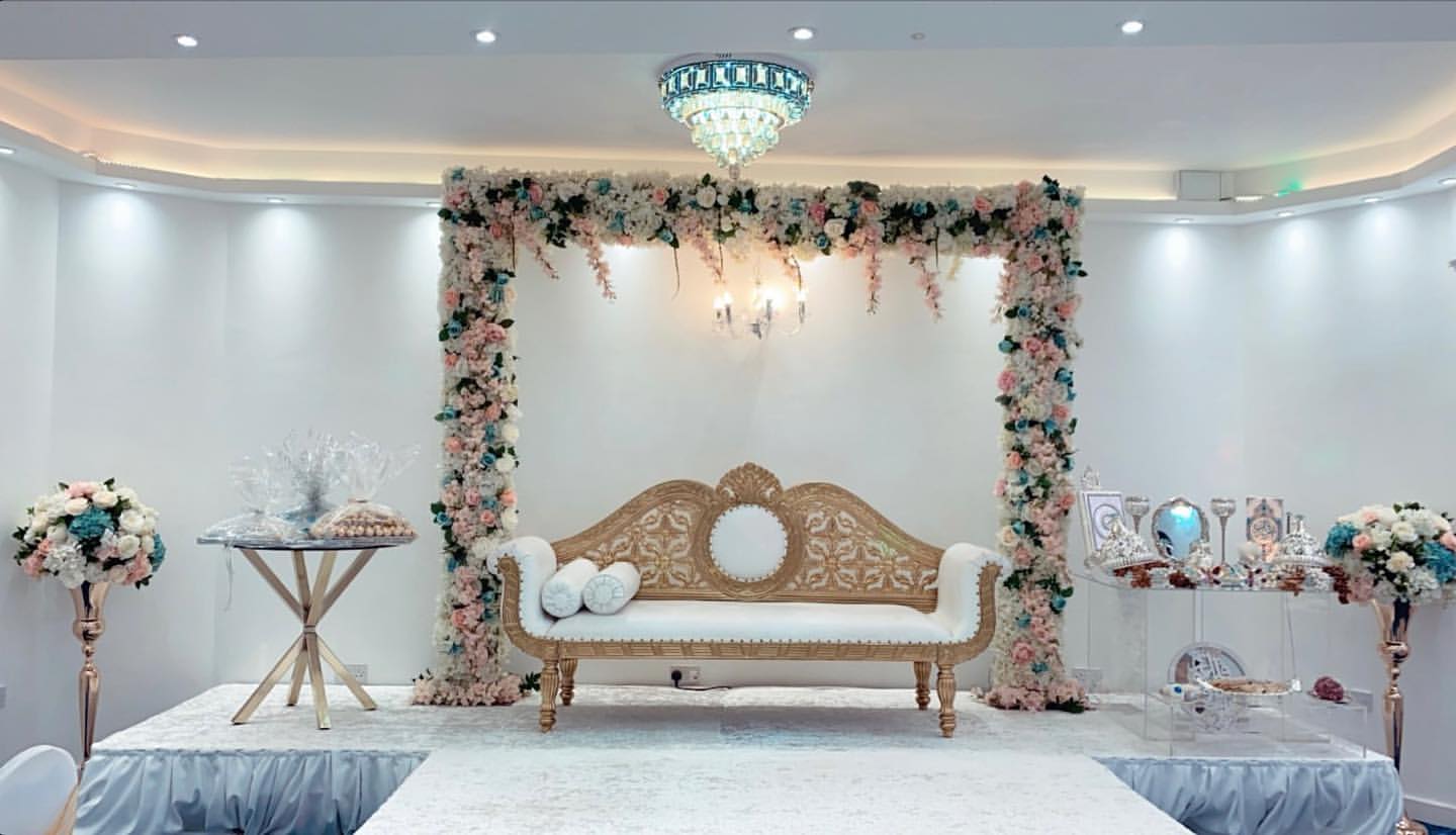Elegant event space at Oscaar Banqueting with floral backdrop, ideal for weddings.