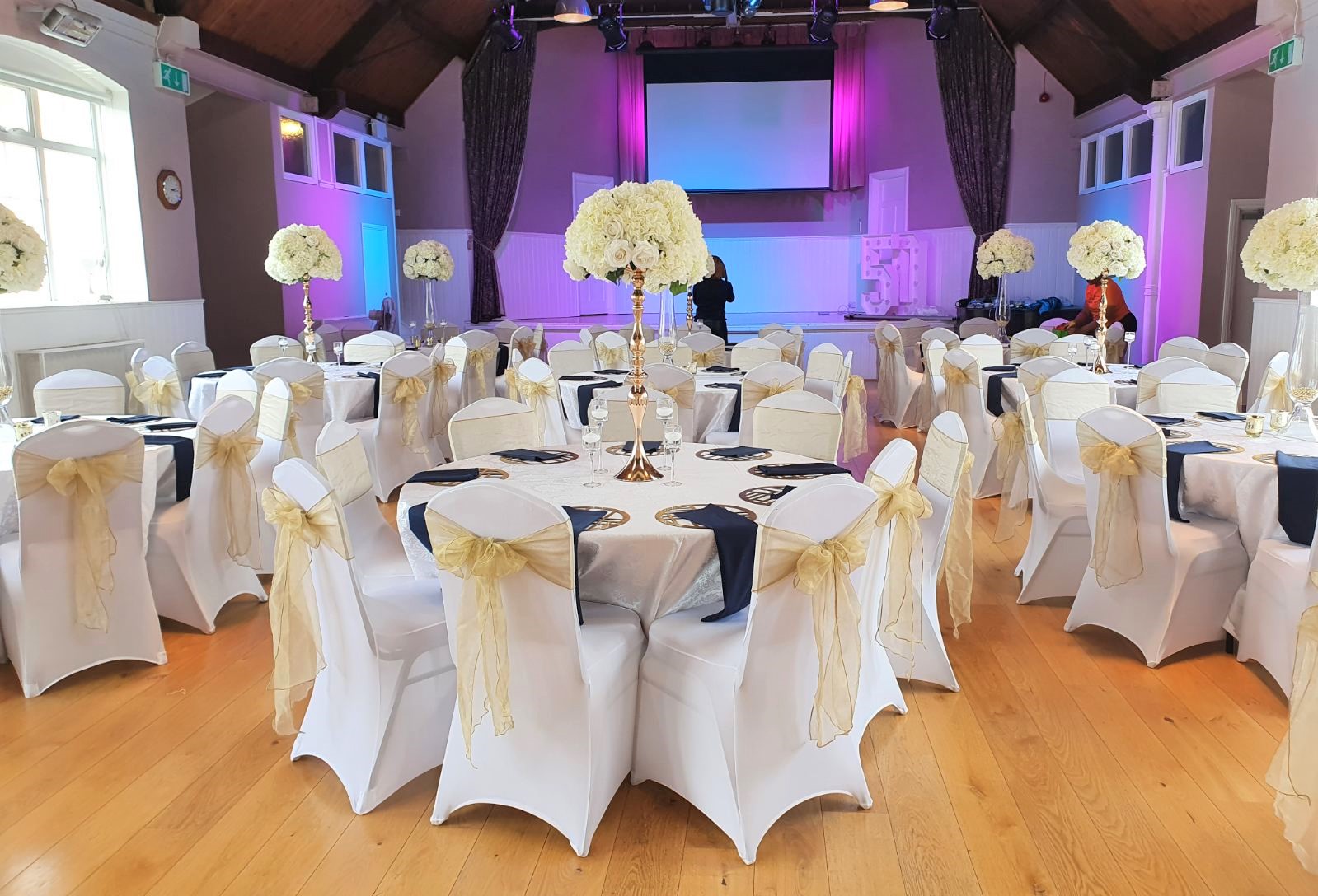 Elegant event space with round tables, ideal for weddings and formal gatherings.