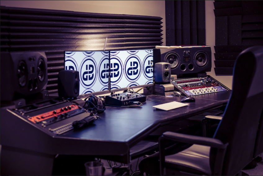 Modern audio production studio with dual monitors for music workshops and events.