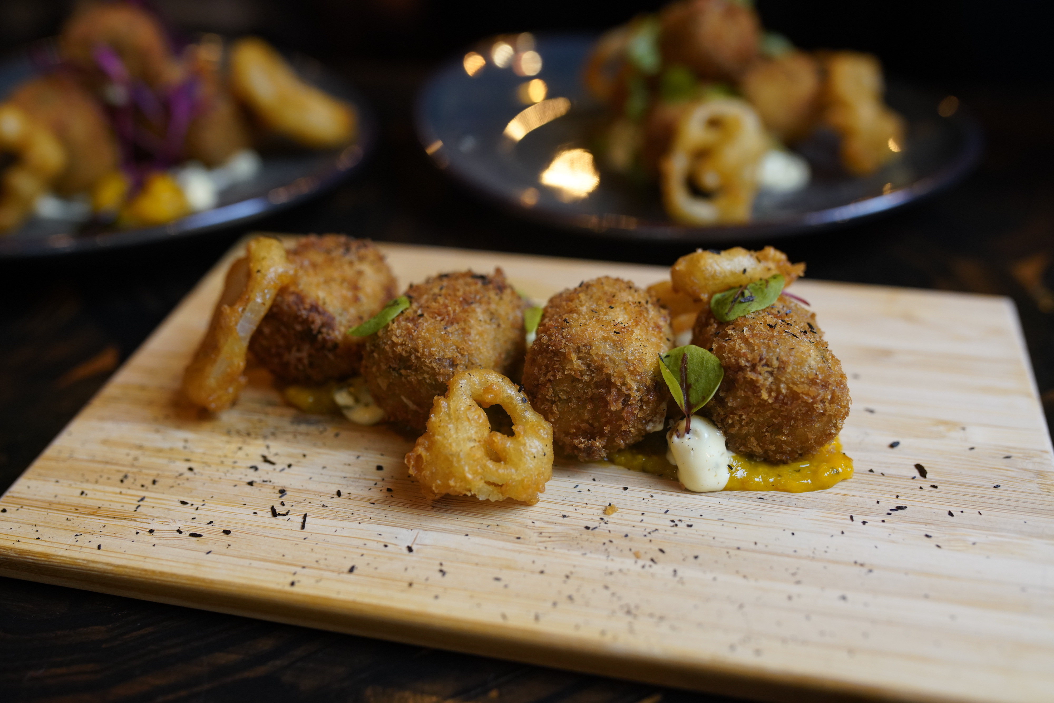 Golden-brown croquettes on a wooden board, ideal for upscale catering events.