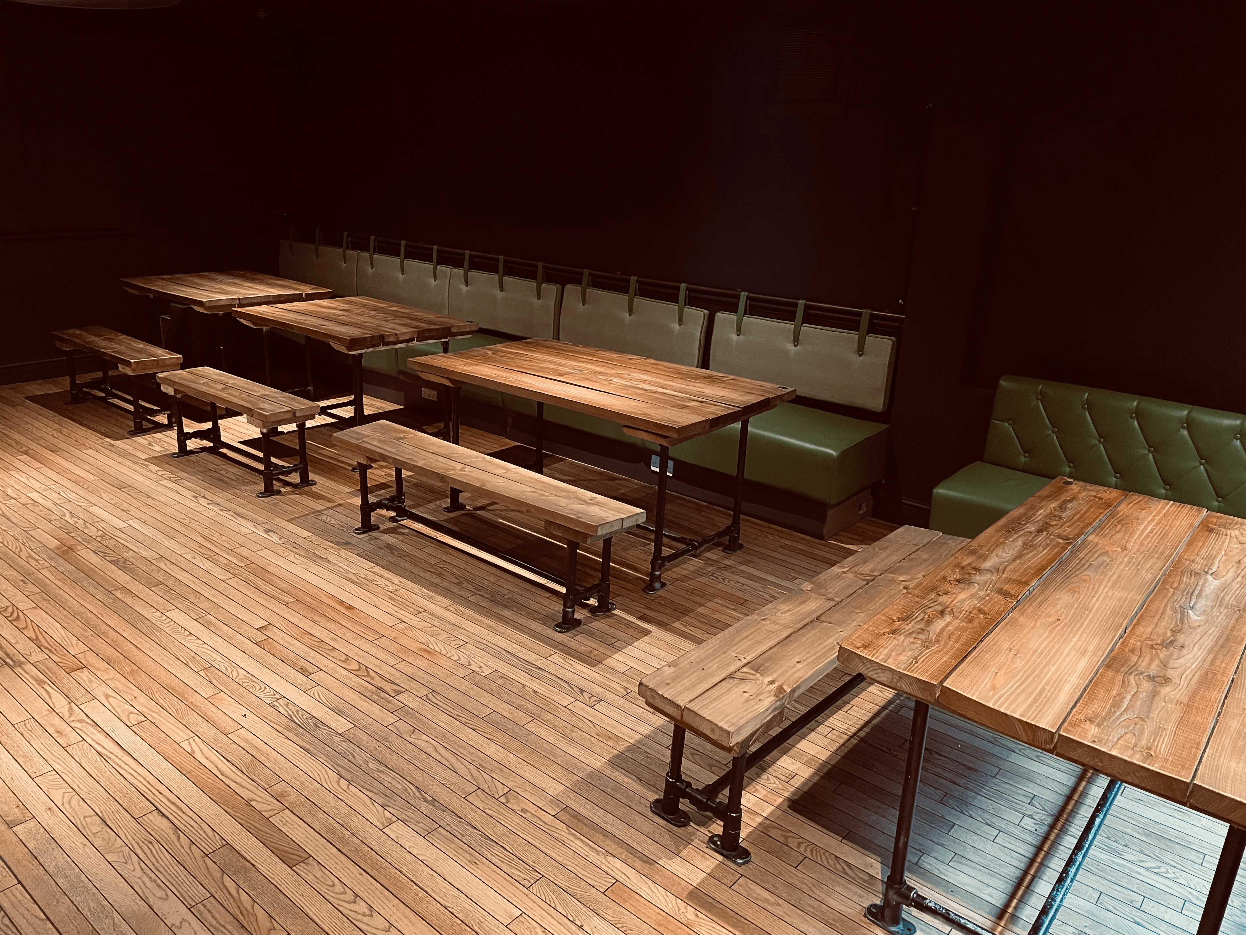 Versatile event space with wooden tables, ideal for casual gatherings and workshops.