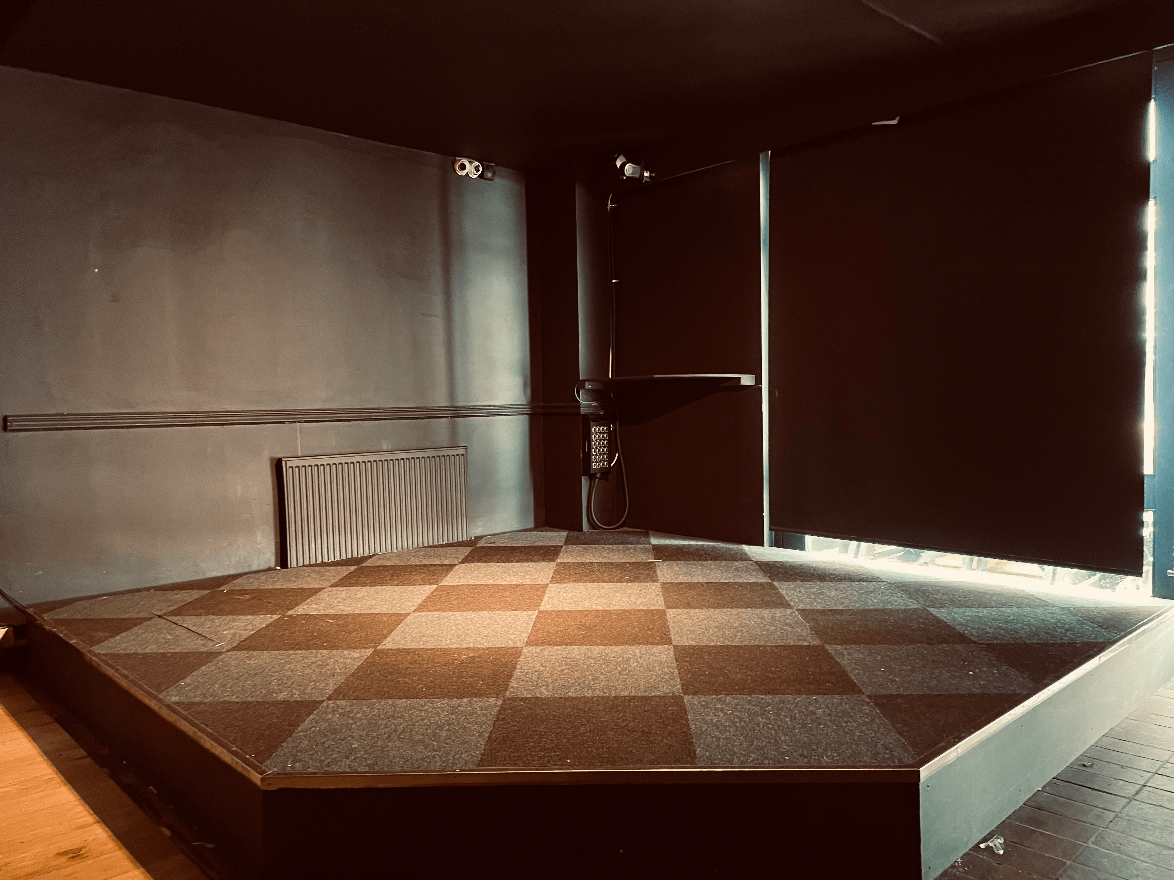 Versatile event space with elevated stage, ideal for presentations and performances.