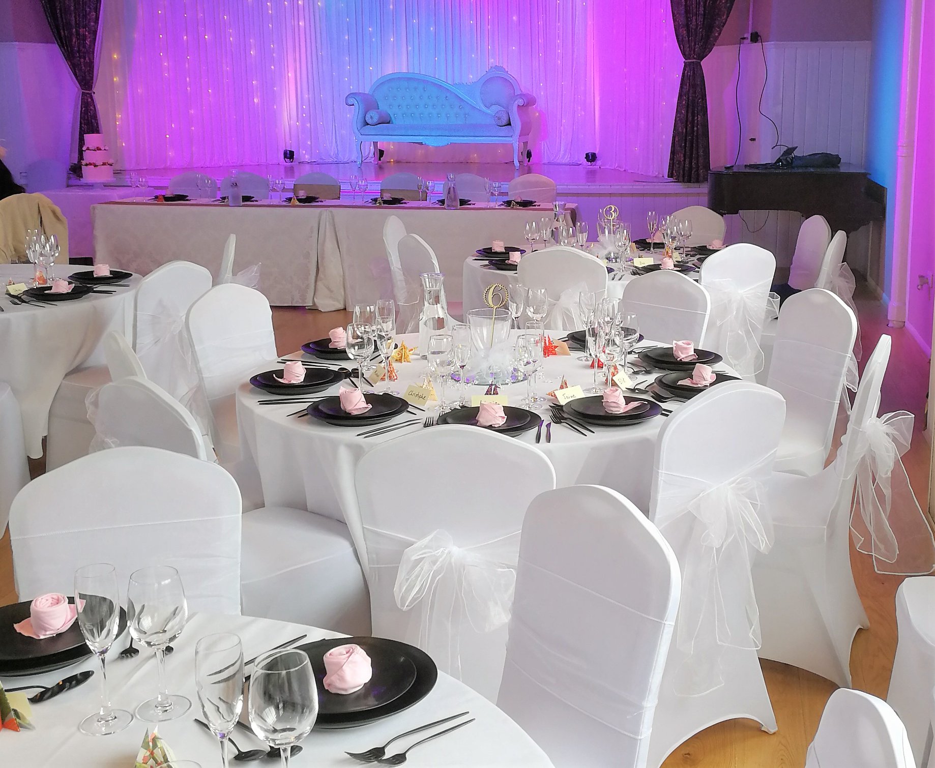 Elegant event space with white table settings, ideal for weddings and formal gatherings.