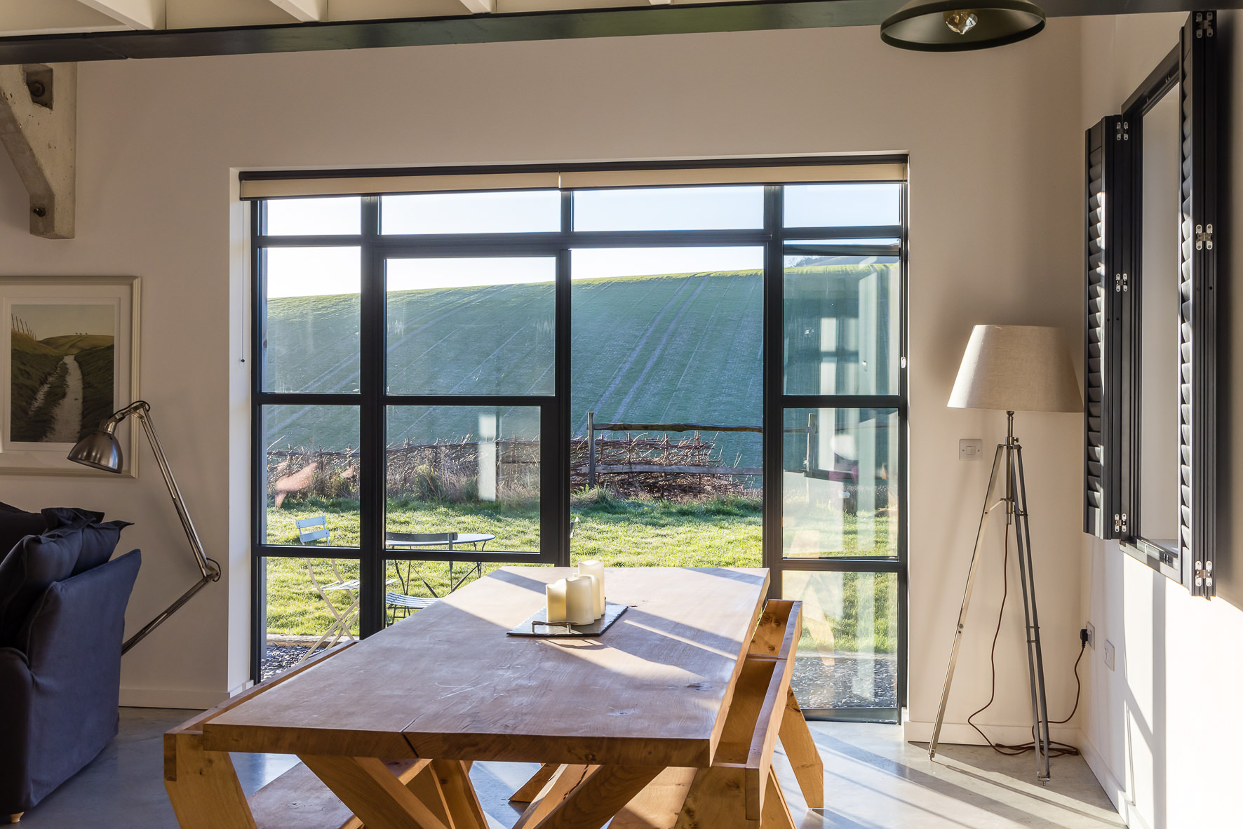 Modern meeting space with large wooden table and scenic windows at The Grain Store Lewes.