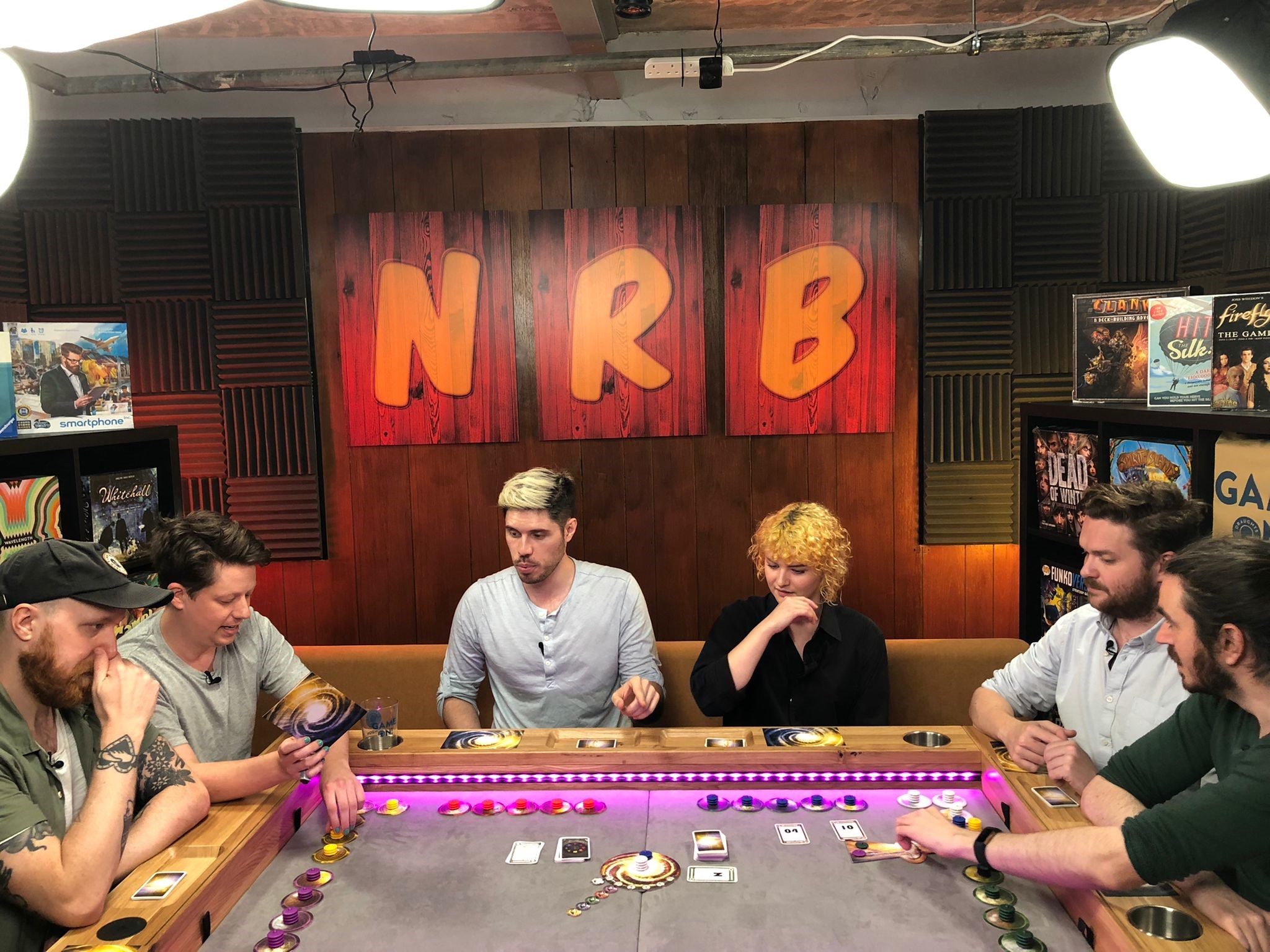 Group at gaming table in vibrant studio, ideal for team-building and networking events.