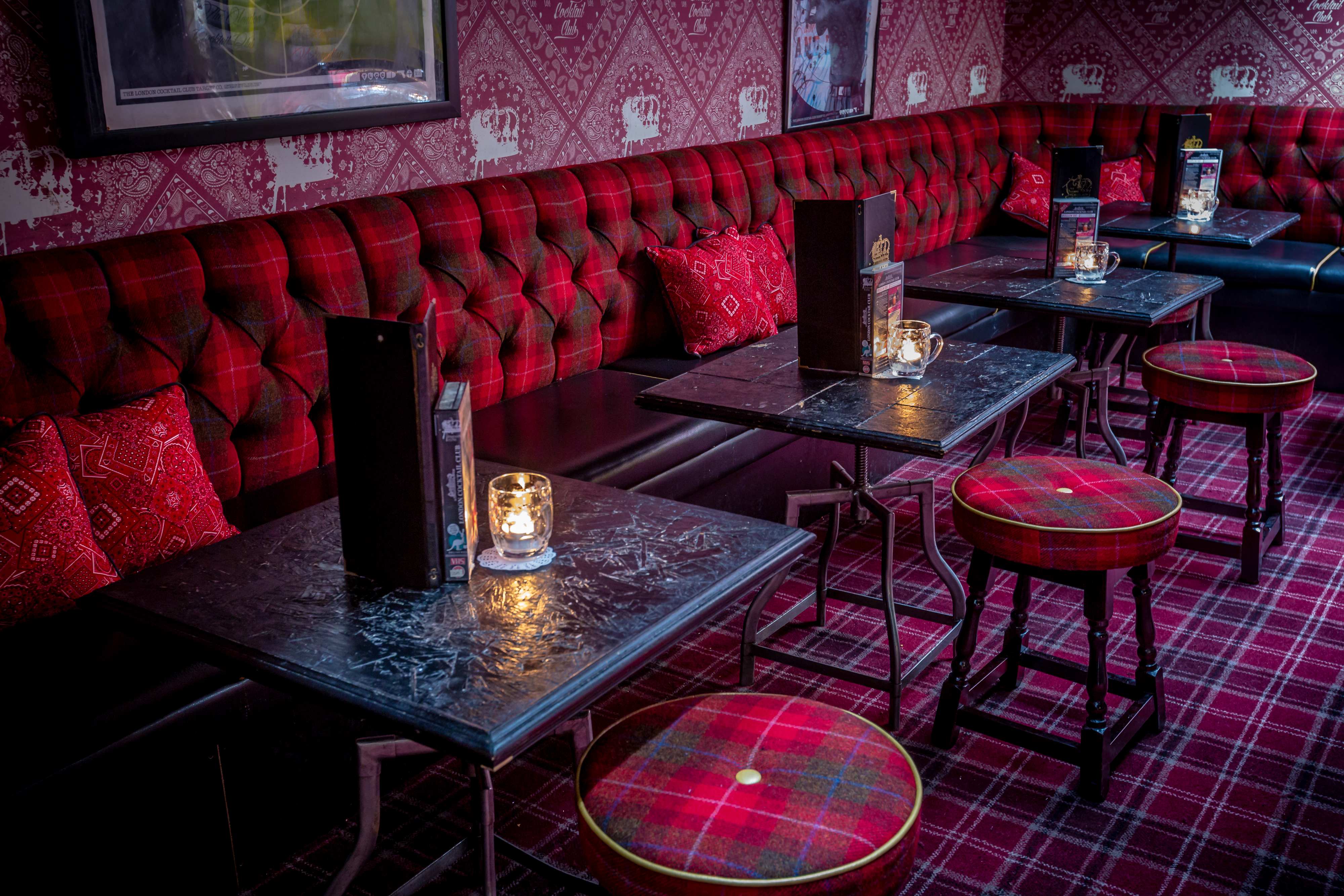 Stylish event space at The Cocktail Club, featuring plush red seating for gatherings.