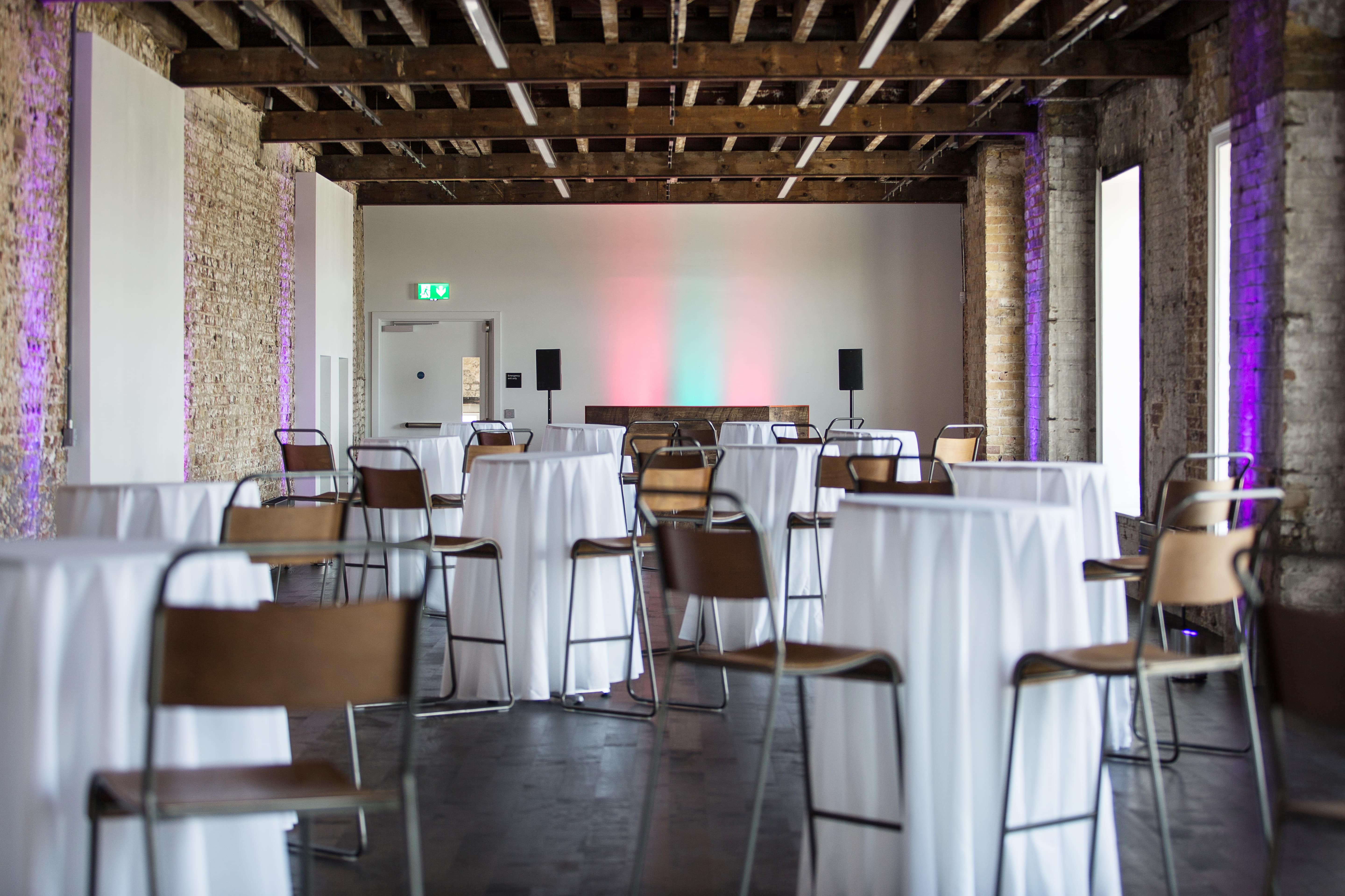Elegant event space with high-top tables for networking and cocktail parties in Woolwich.