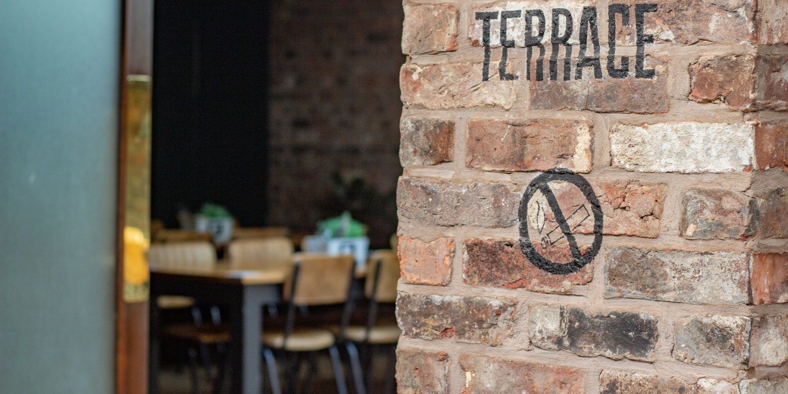 Terrace at Duke Street Market, rustic brick wall, ideal for family-friendly events.
