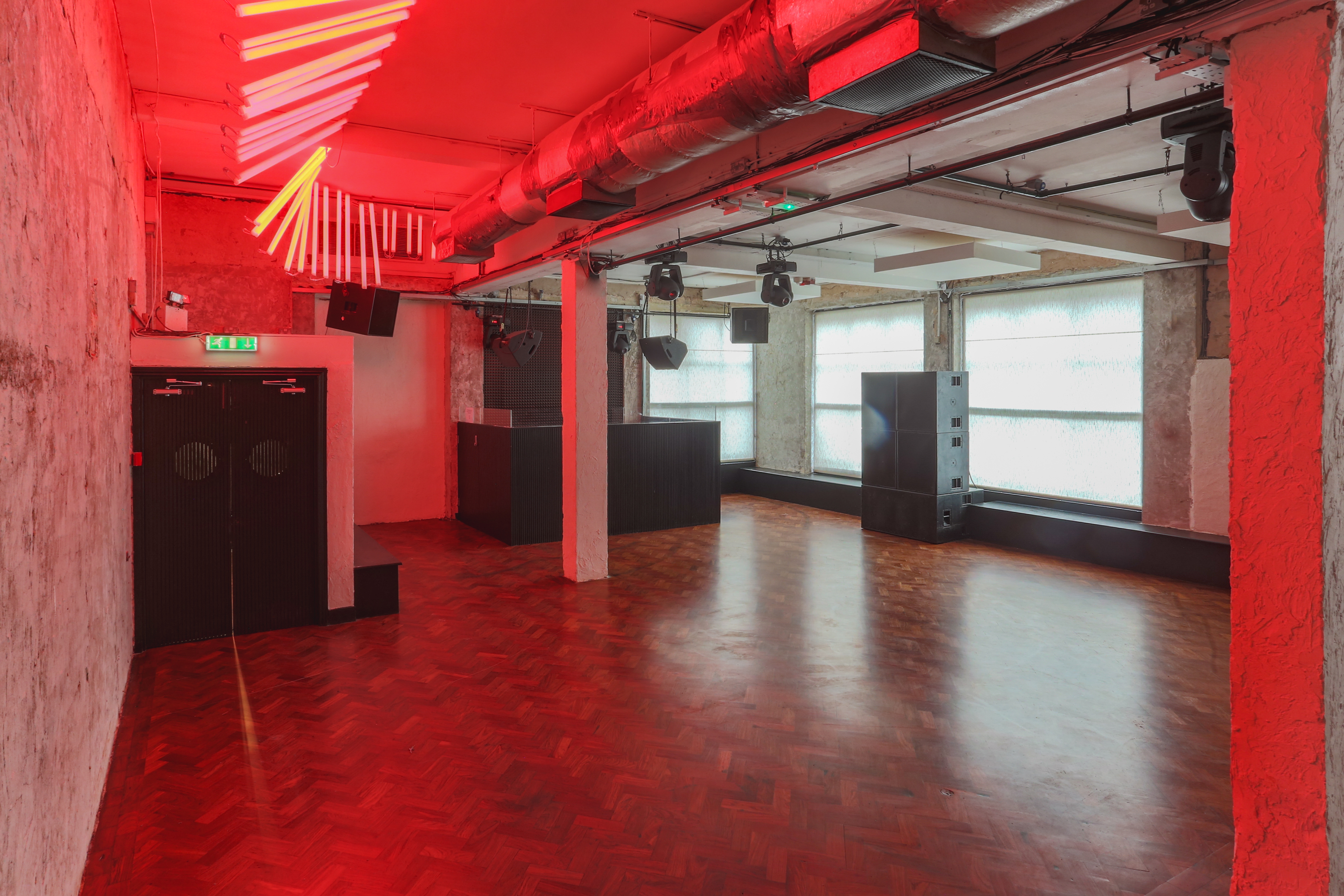 Modern event space with red lighting, ideal for creative functions and networking.