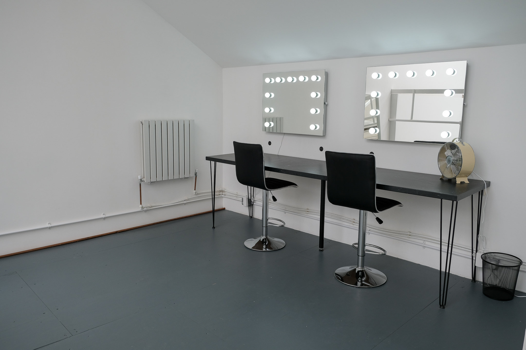 Minimalist makeup stations with illuminated mirrors at Mello Studios Hackney for event grooming.