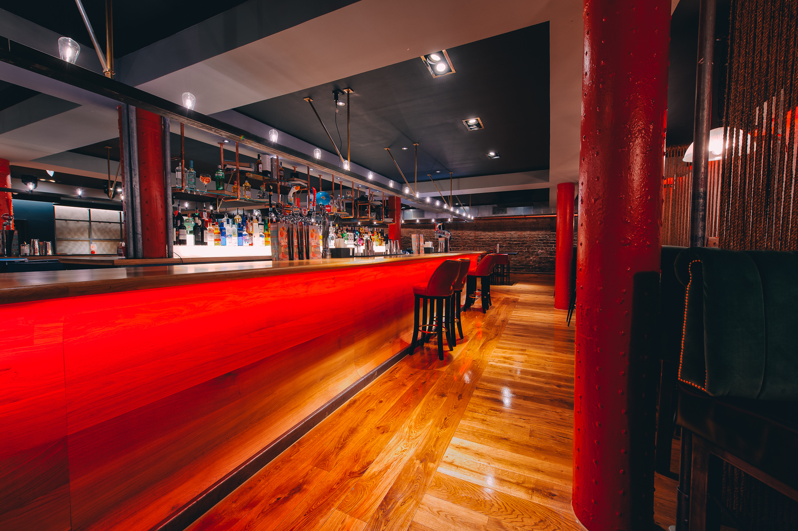 Modern bar venue in Glasgow with red backlit counter, ideal for networking events.