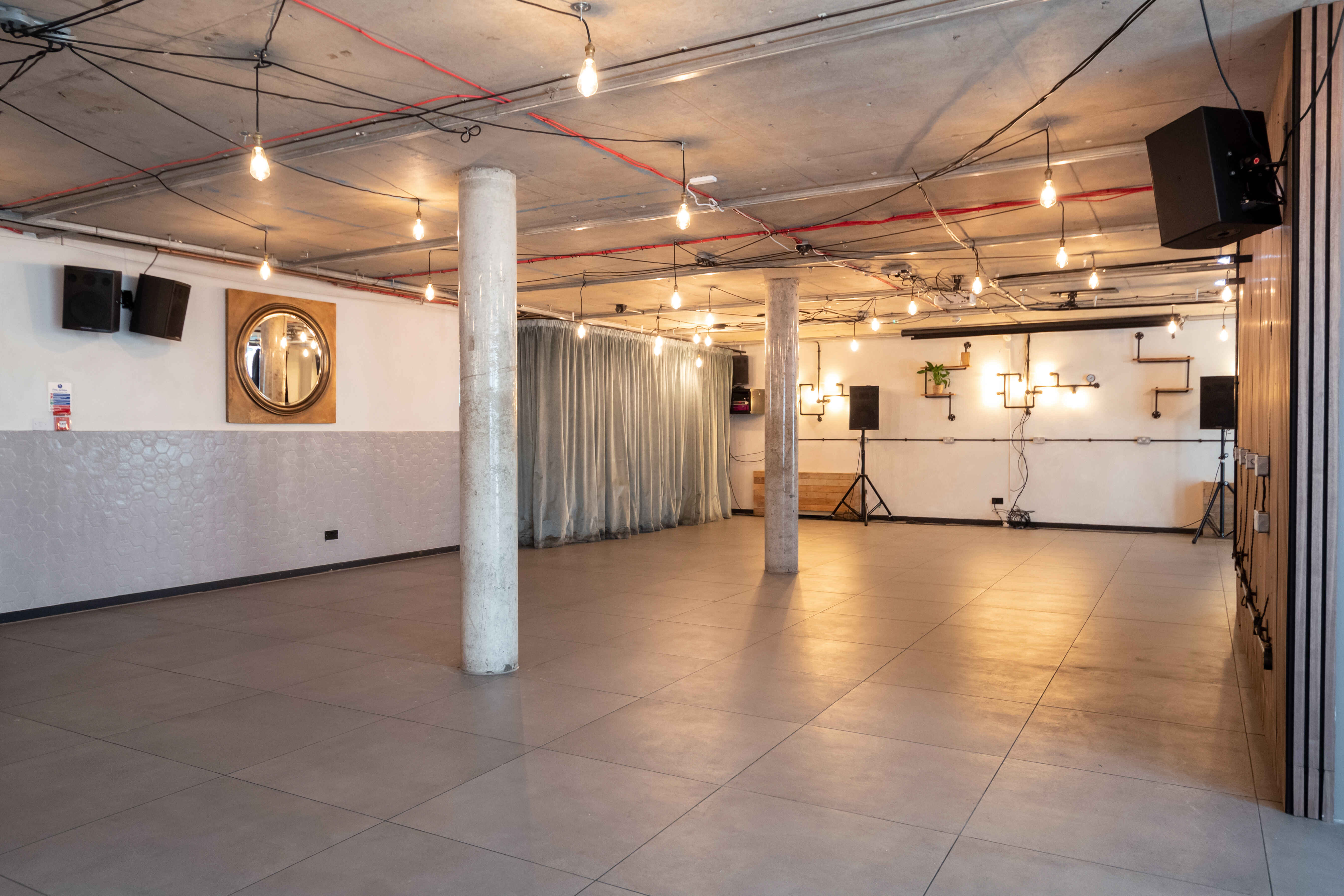 Versatile event space with polished concrete floor, ideal for meetings and workshops.