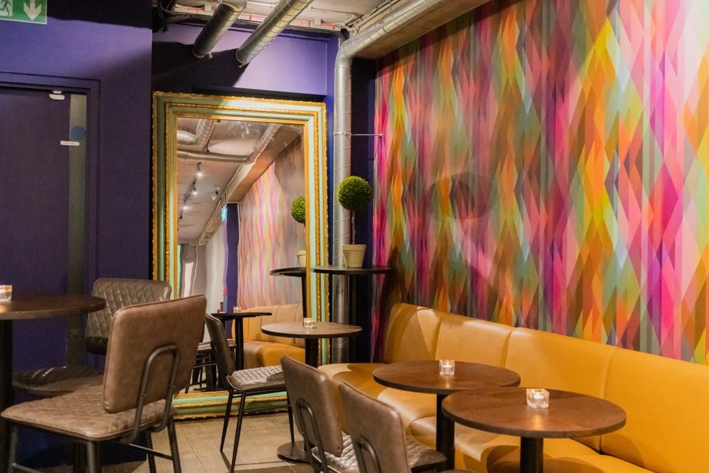 Vibrant event space at Brooks Mews Wine House with colorful wall, ideal for gatherings.