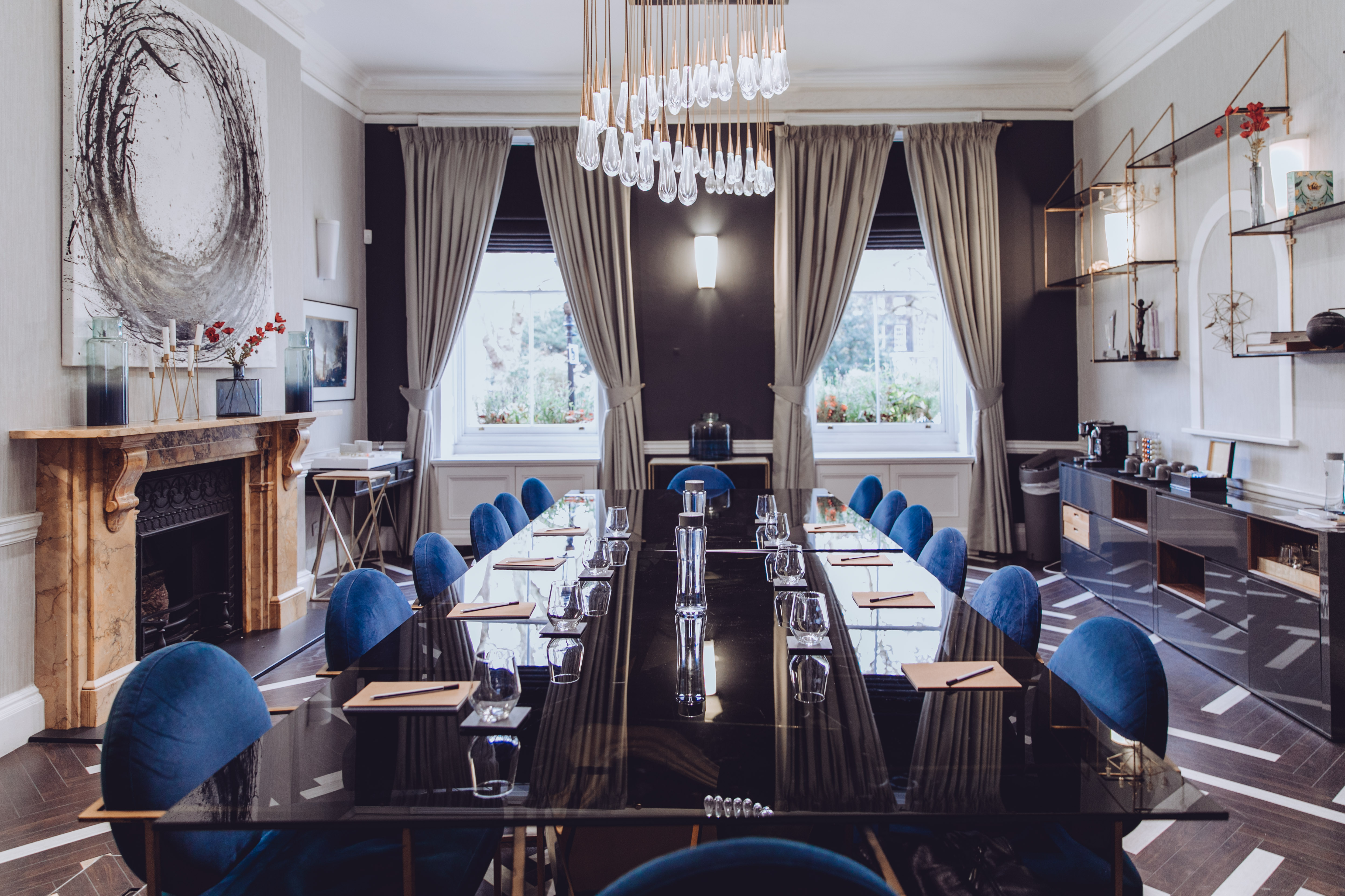 Sophisticated meeting room with sleek black table and plush blue chairs for corporate events.