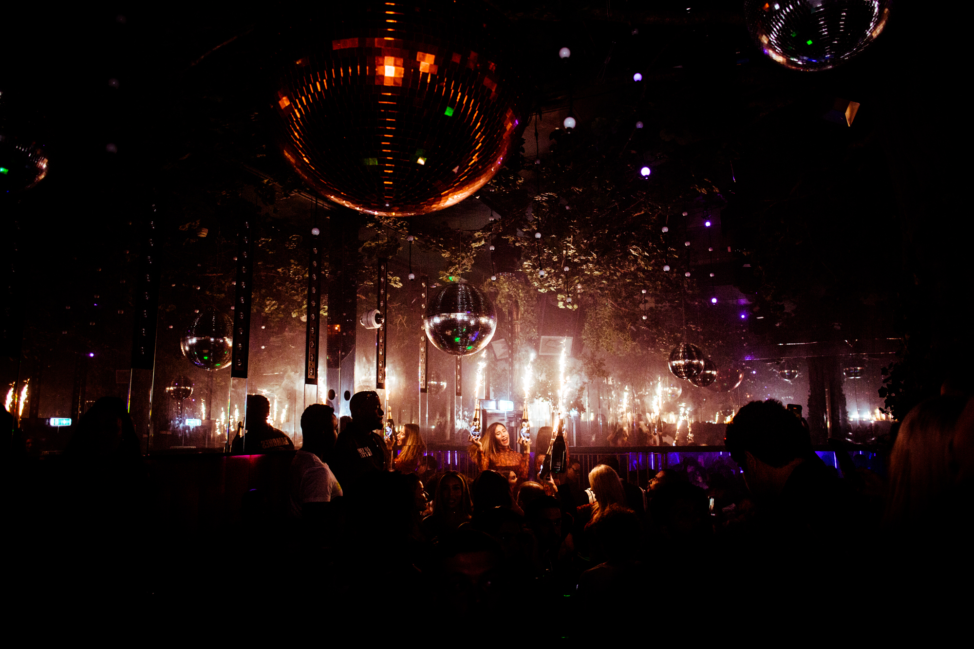 Vibrant Wyld Club event space with disco balls and sparklers for energetic celebrations.