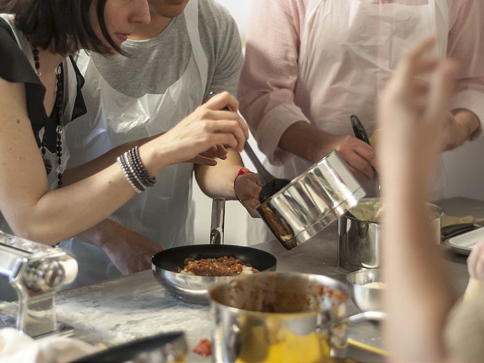 In-person group cooking class at Jenius Social, showcasing teamwork and engagement.