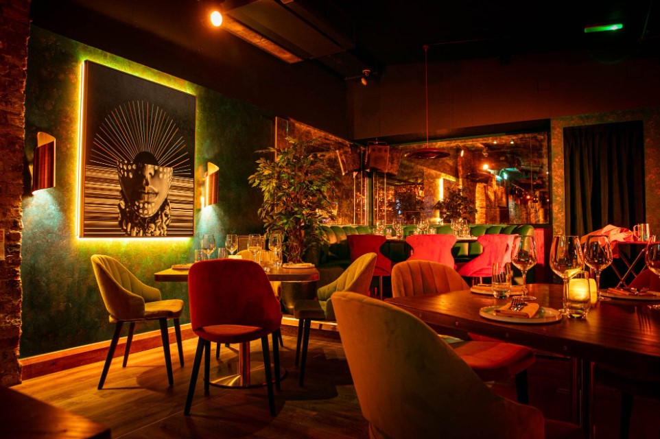 Vibrant LUNA LONDON restaurant with colorful chairs, ideal for upscale events and gatherings.