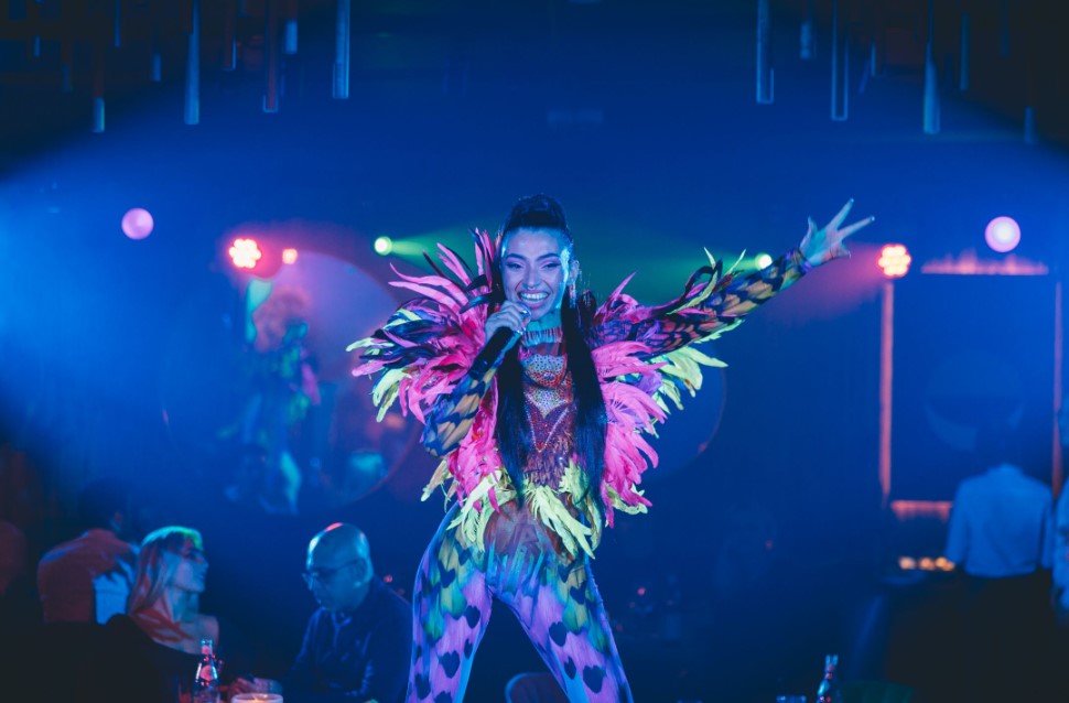 Vibrant performer in colorful costume at LUNA LONDON event stage.