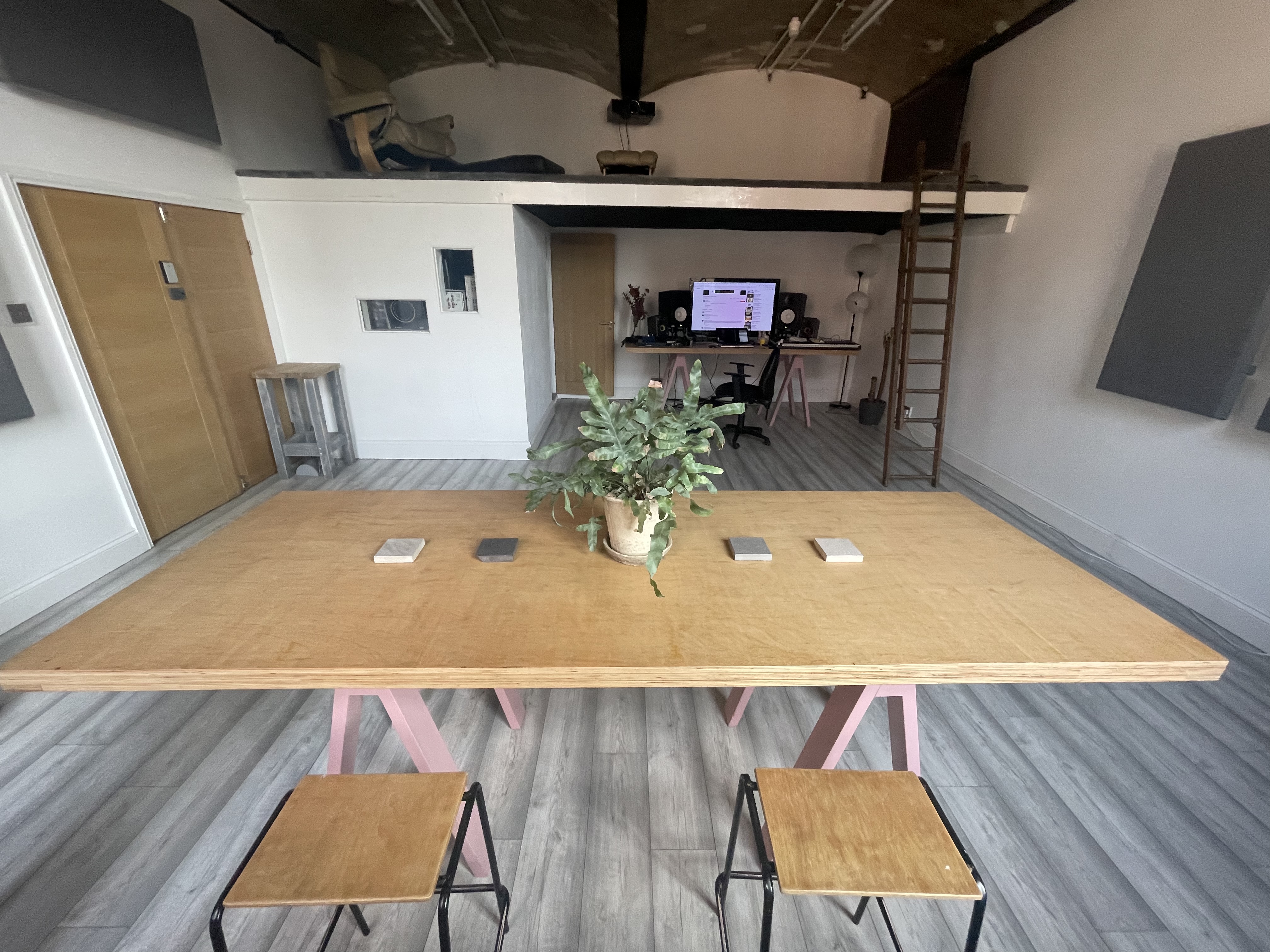 Modern minimalist meeting space with large wooden table for workshops and presentations.