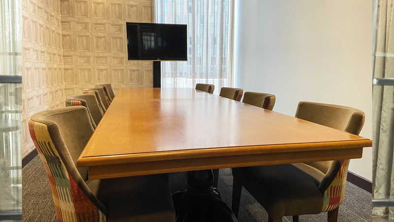 Modern boardroom with wooden table, ideal for meetings and presentations.