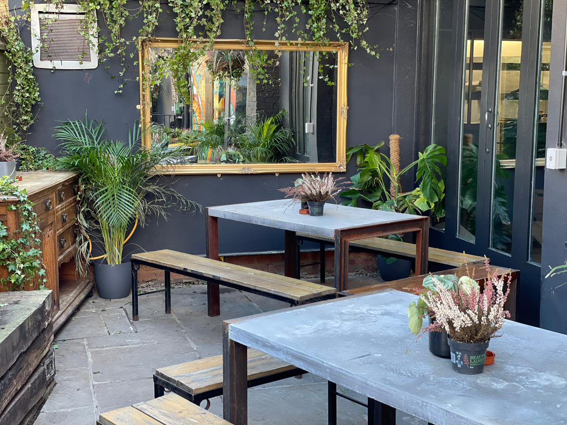 Stylish outdoor meeting space with concrete tables in The Enchanted Garden, ideal for gatherings.