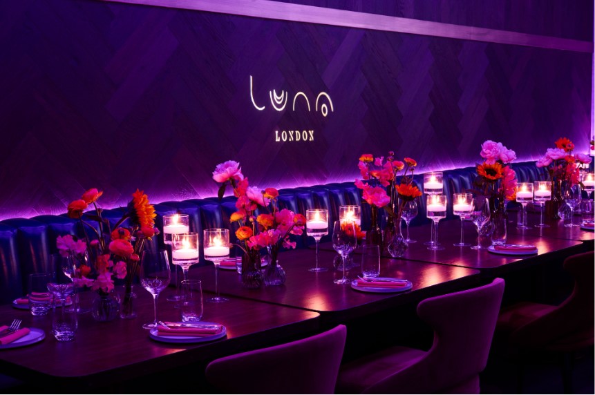Elegant Luna Lounge in London with vibrant flowers and ambient purple lighting for upscale events.