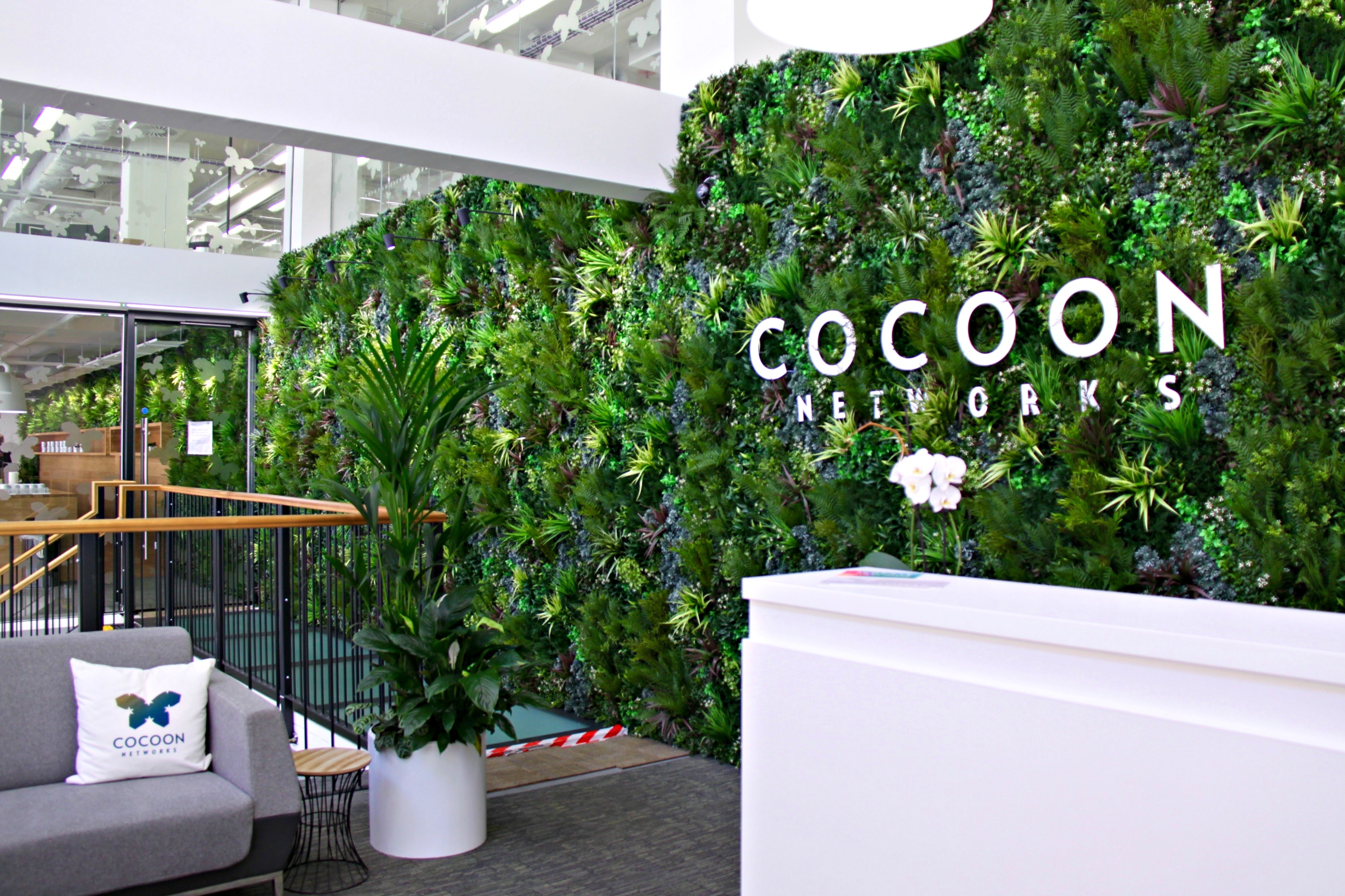 Modern reception area with lush green wall for sustainable events at Cocoon Space.