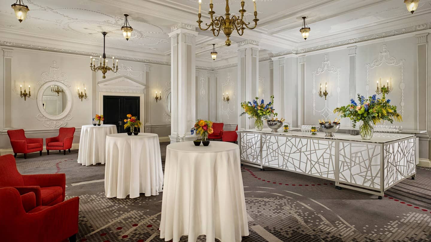 Elegant event space with high-top tables and floral decor, ideal for upscale receptions.