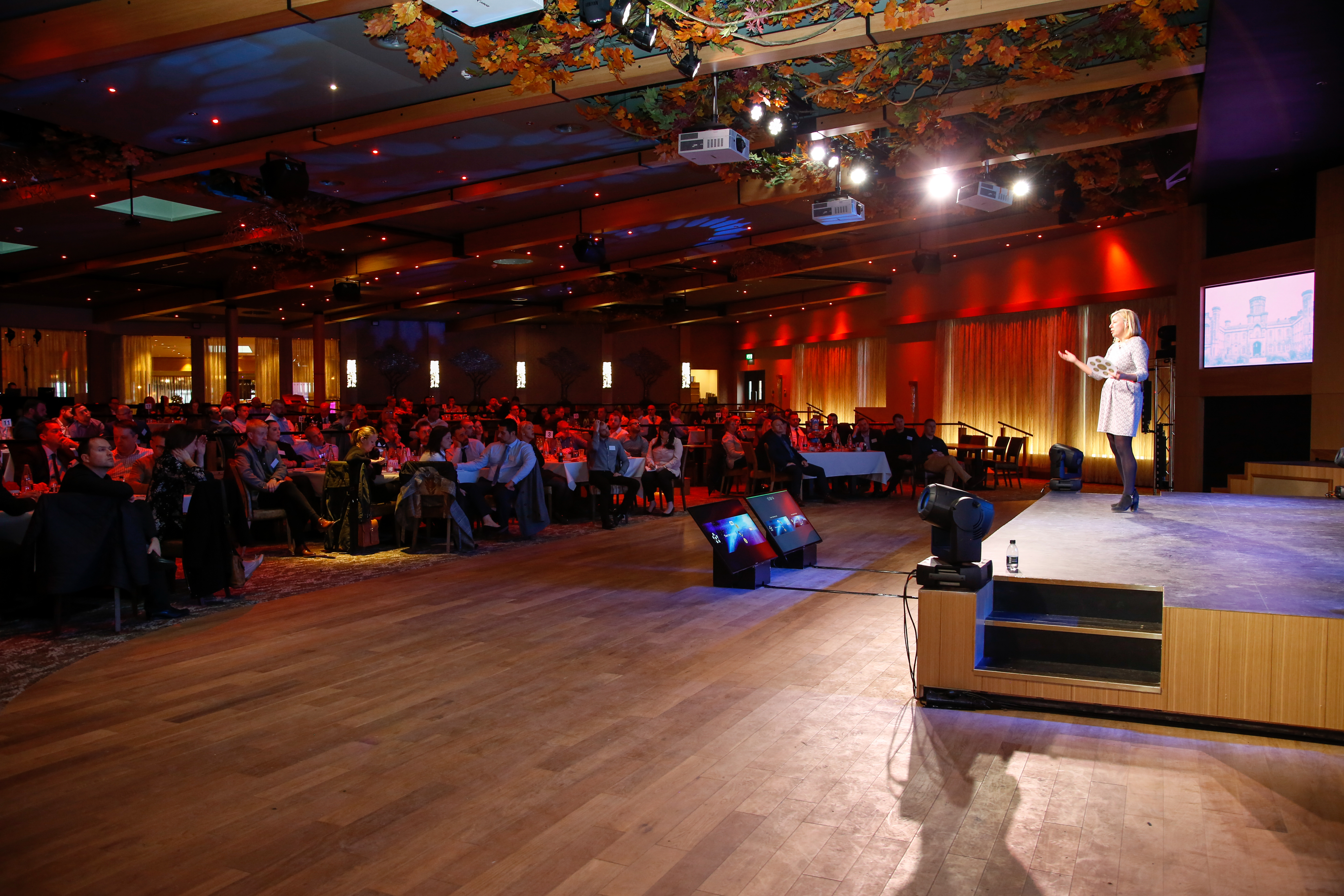 Event at The Evesham, Studley Castle: speaker engaging audience in a vibrant venue.