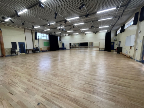 Spacious event space at Copthall School with polished wooden floors for workshops and conferences.