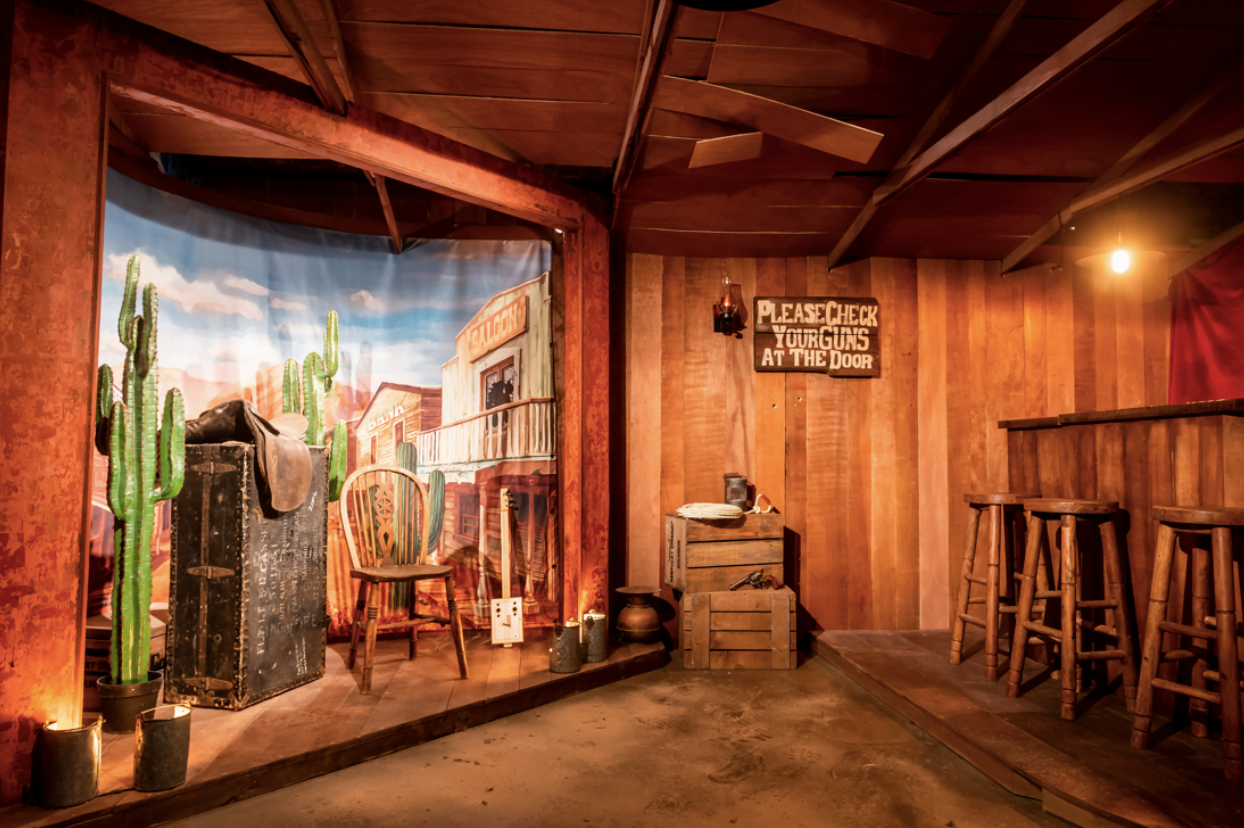Rustic Western-themed event space with wooden walls, ideal for parties and gatherings.