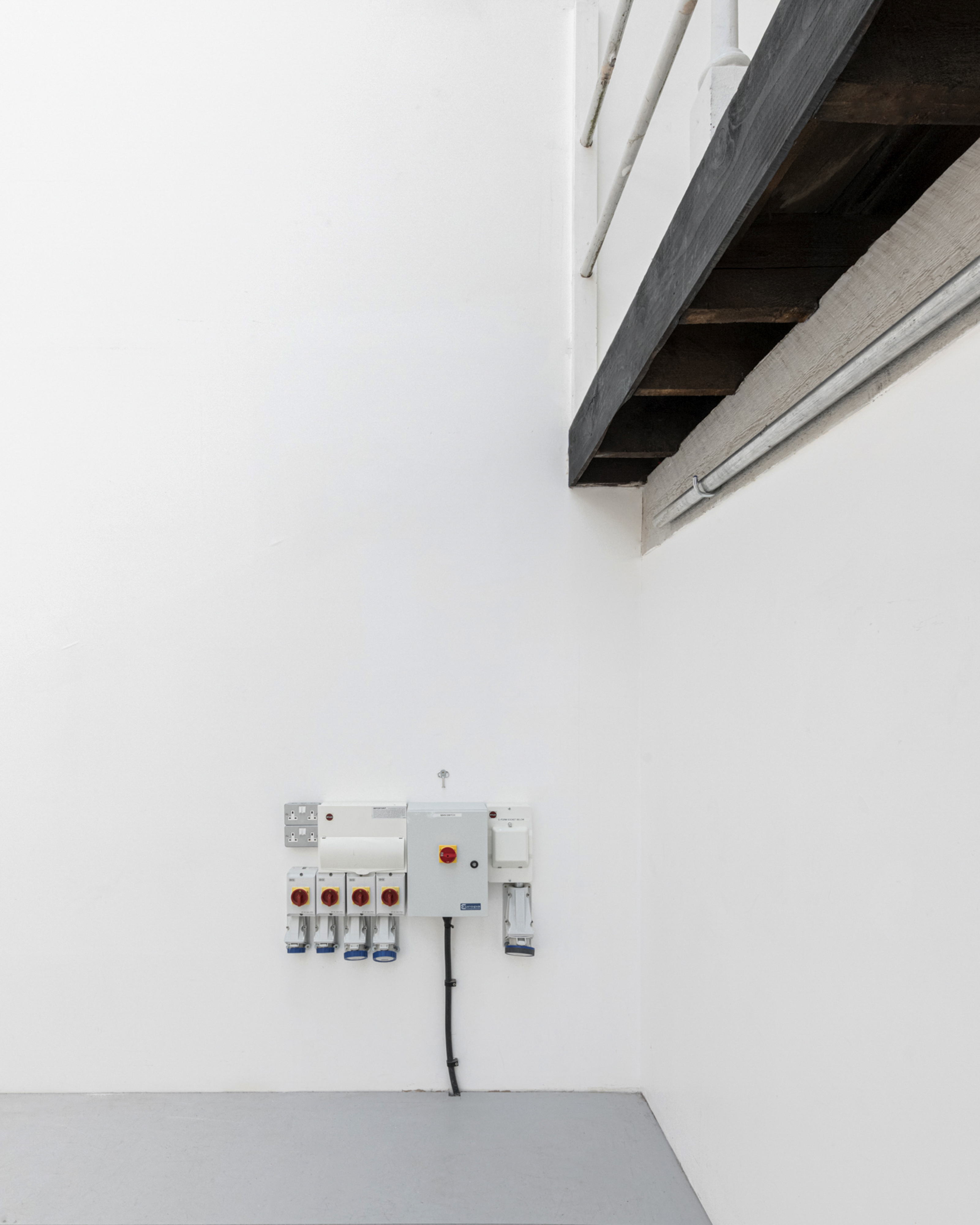 Minimalist meeting space with white walls, ideal for workshops and intimate gatherings.