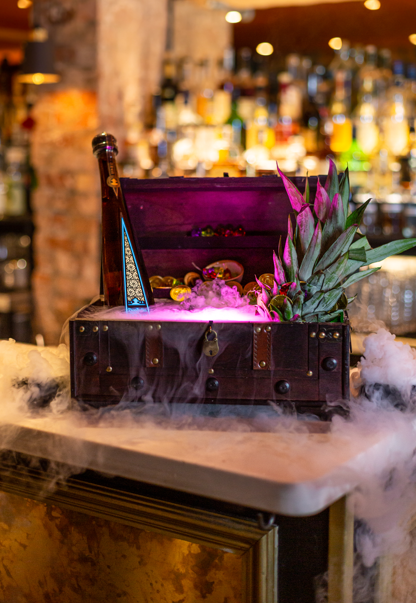 Vibrant treasure chest centerpiece with smoke effects for themed events in Meraki London.