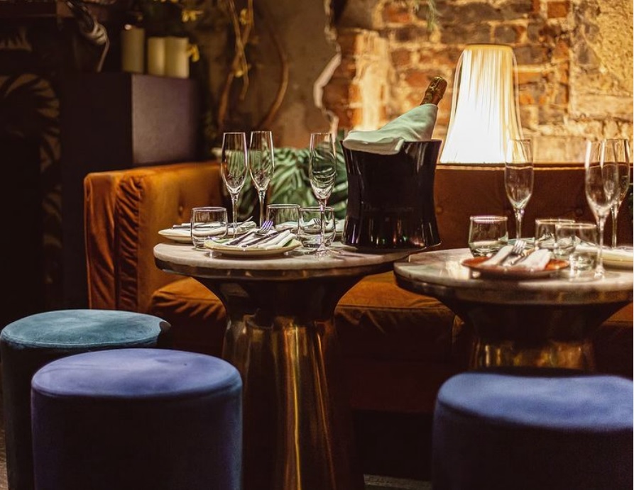 Intimate event setup in The Living Room, Meraki London with elegant dining and warm lighting.