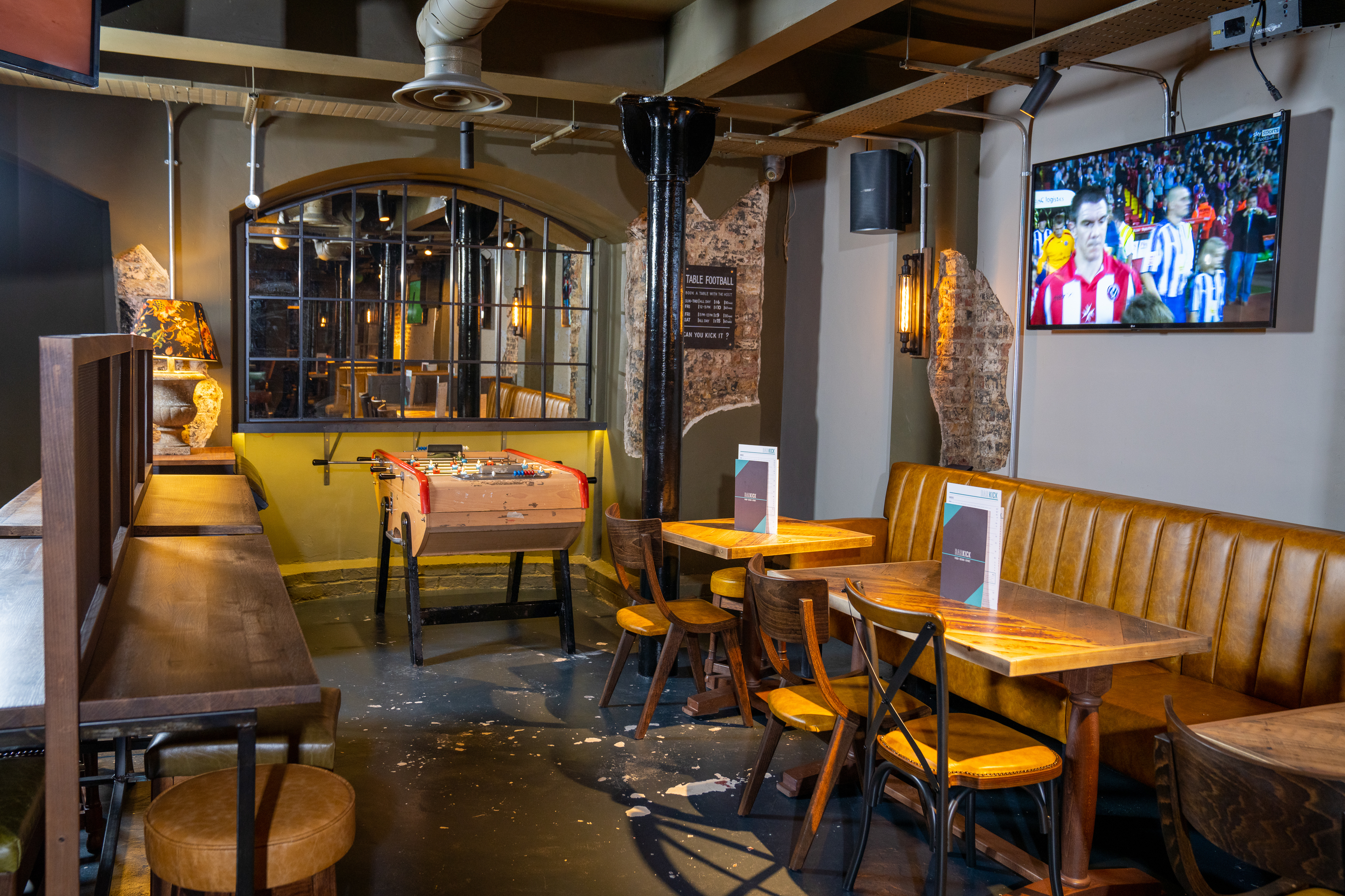 Cozy basement venue with foosball table for social events and meetings at Bar Kick.