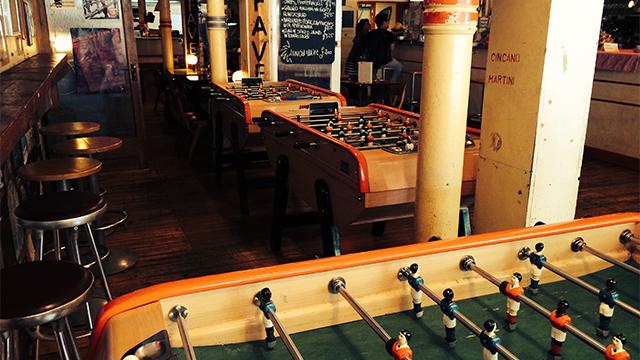Vibrant basement social space with foosball tables for team bonding events.