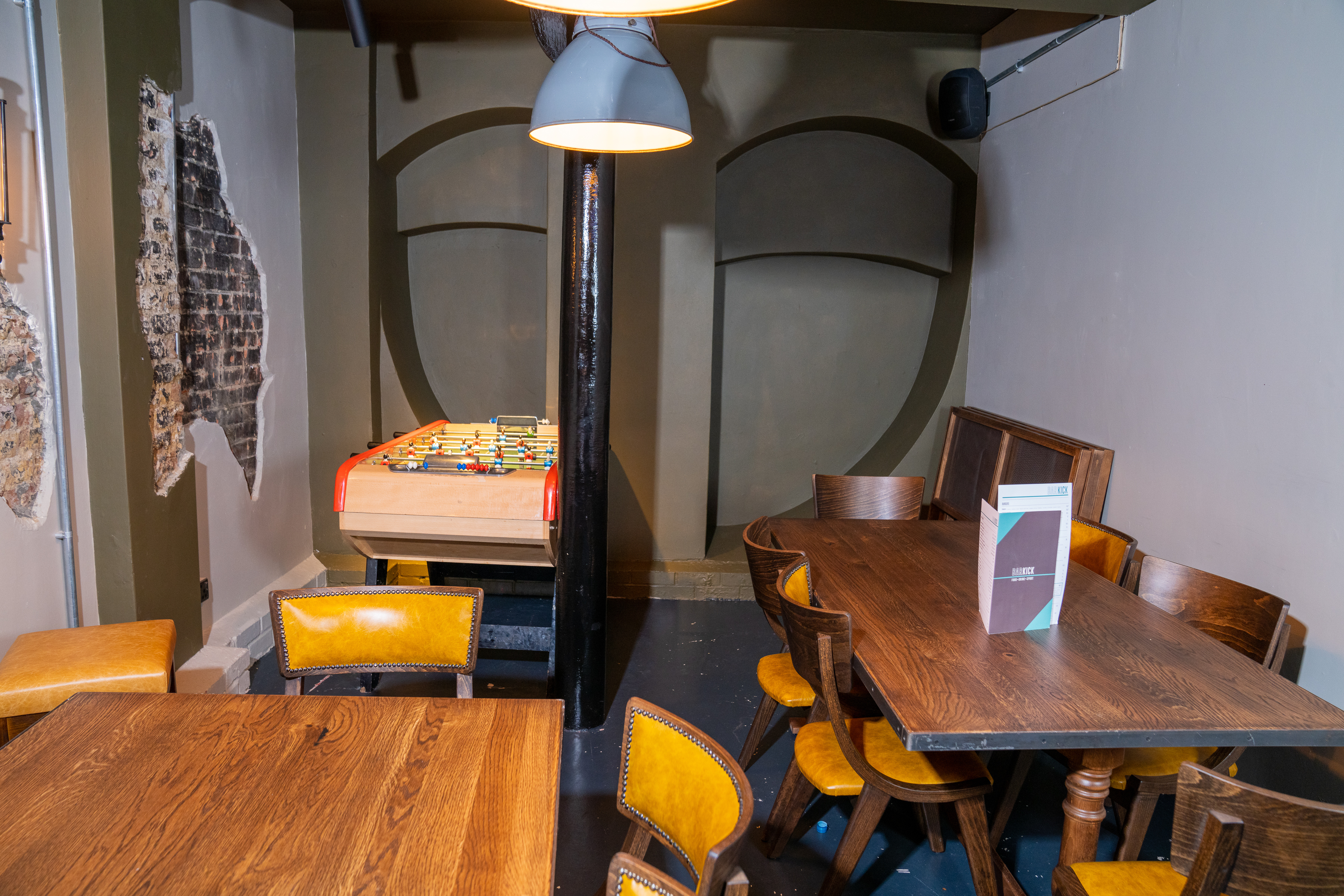 Cozy meeting space with wooden tables, ideal for gatherings and networking at Bar Kick.