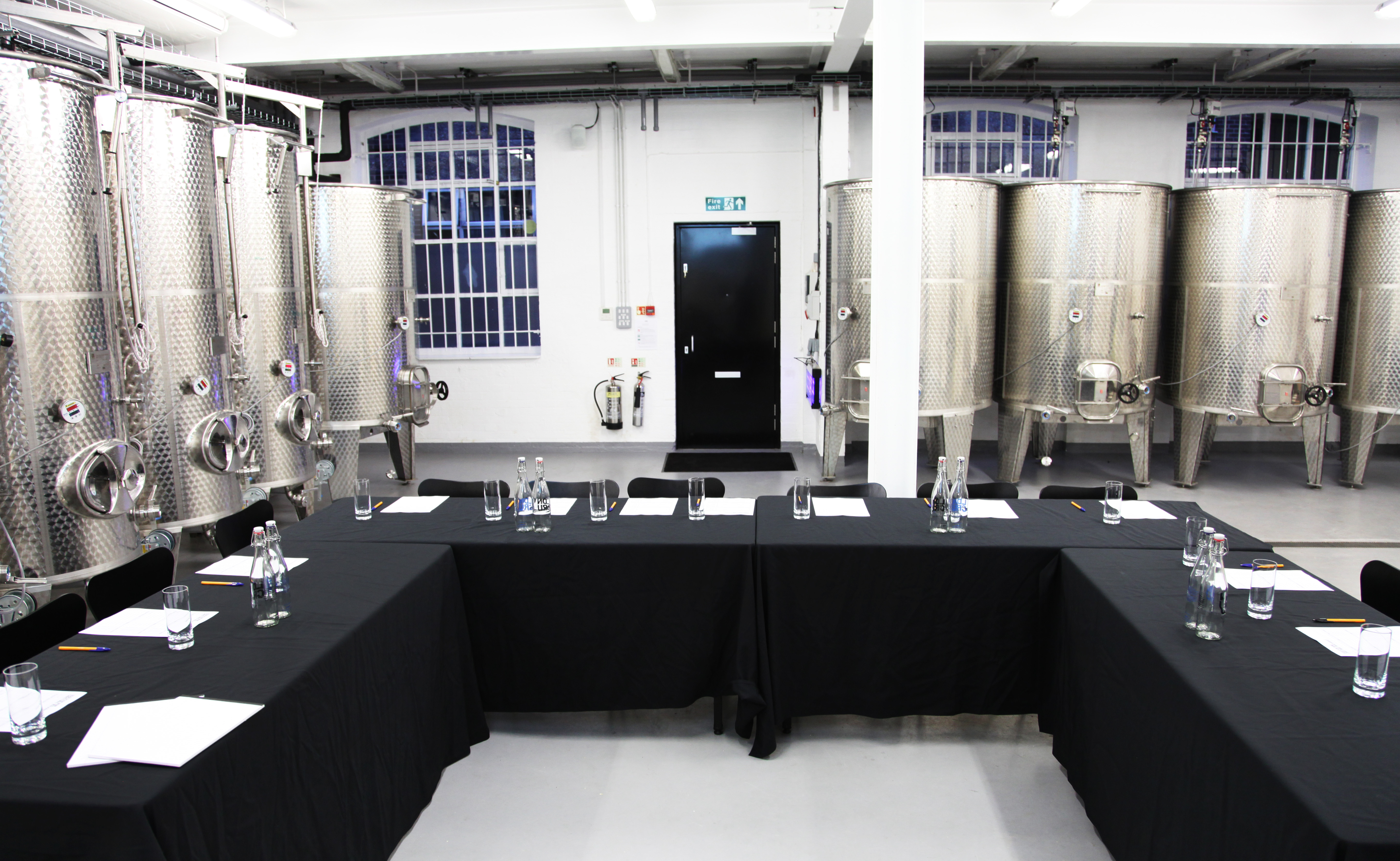 Tank Room at London Cru Winery: modern meeting space with stainless steel tanks, ideal for retreats.