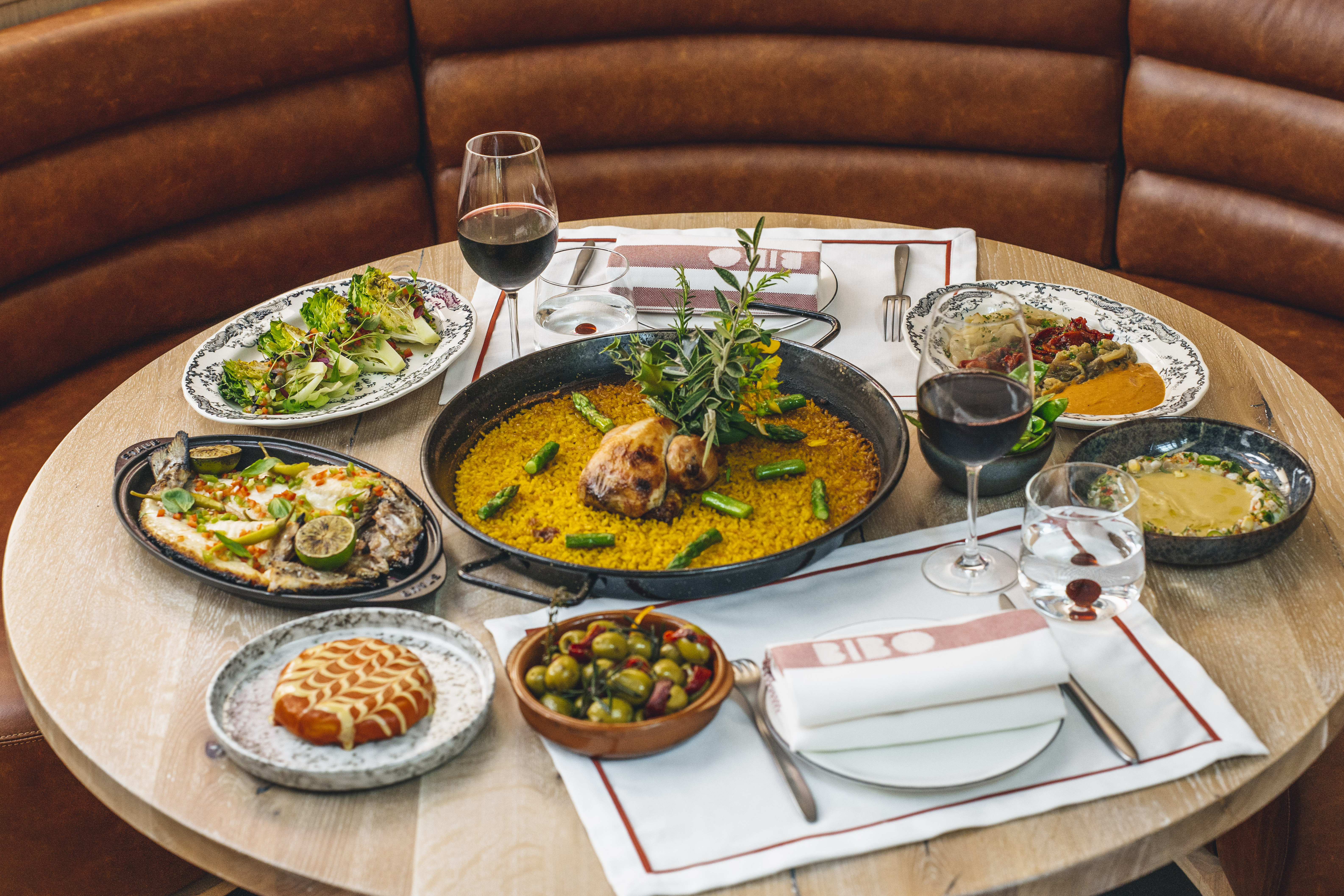 Upscale dining event at BIBO Virgin Hotels Shoreditch with vibrant paella centerpiece.