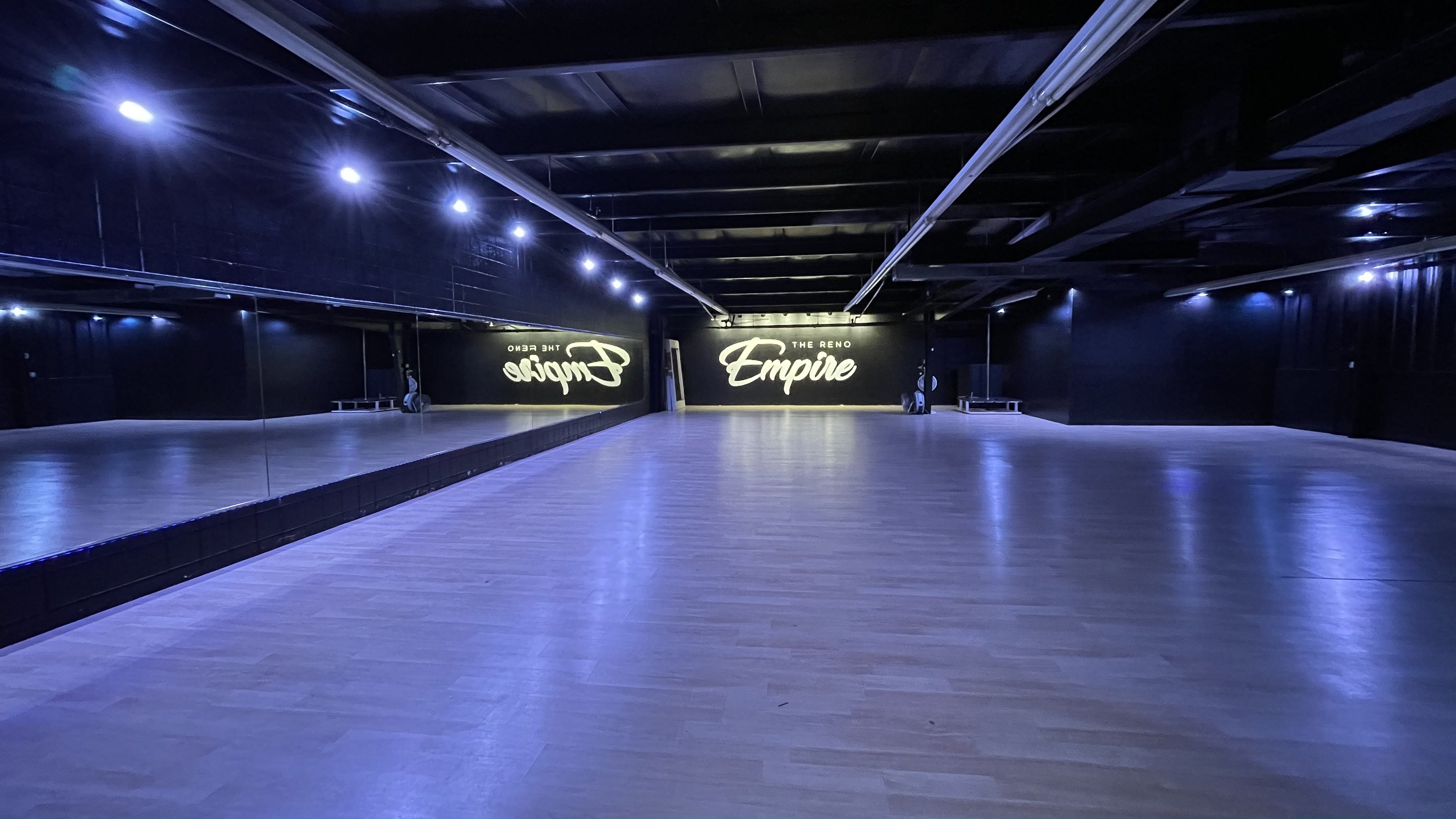 Spacious modern event space with polished wood floor for corporate events and workshops.