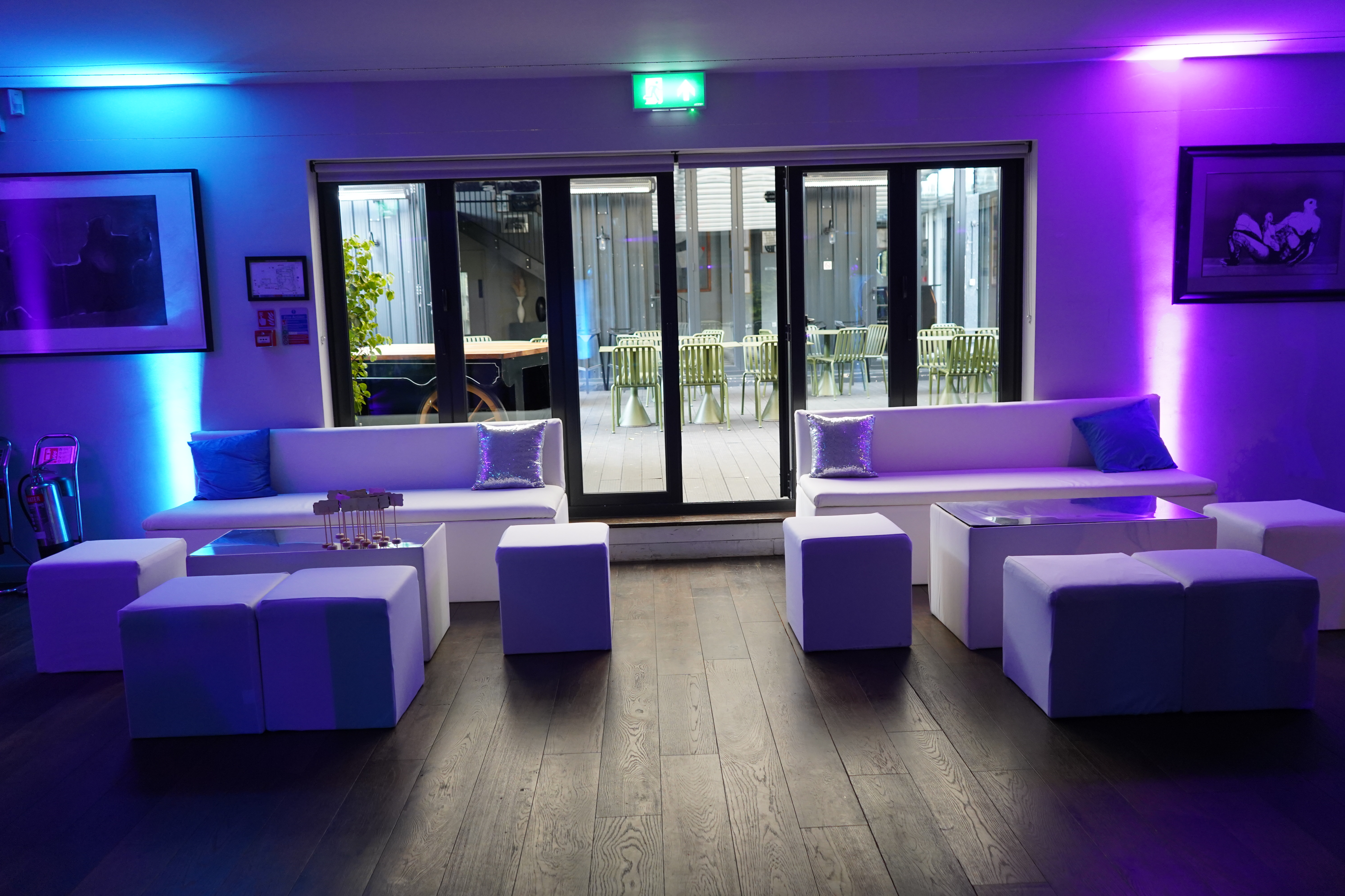 Modern lounge in The V8 Room, featuring sleek white furniture for events and networking.