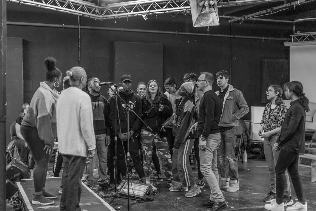 Diverse group rehearsing at McQueens Theatre for a collaborative performance event.