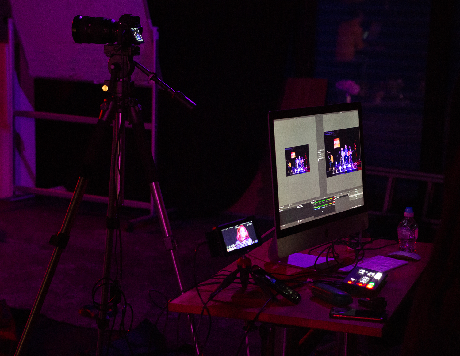 Hybrid event production setup at McQueens Theatre with cameras and live feeds.