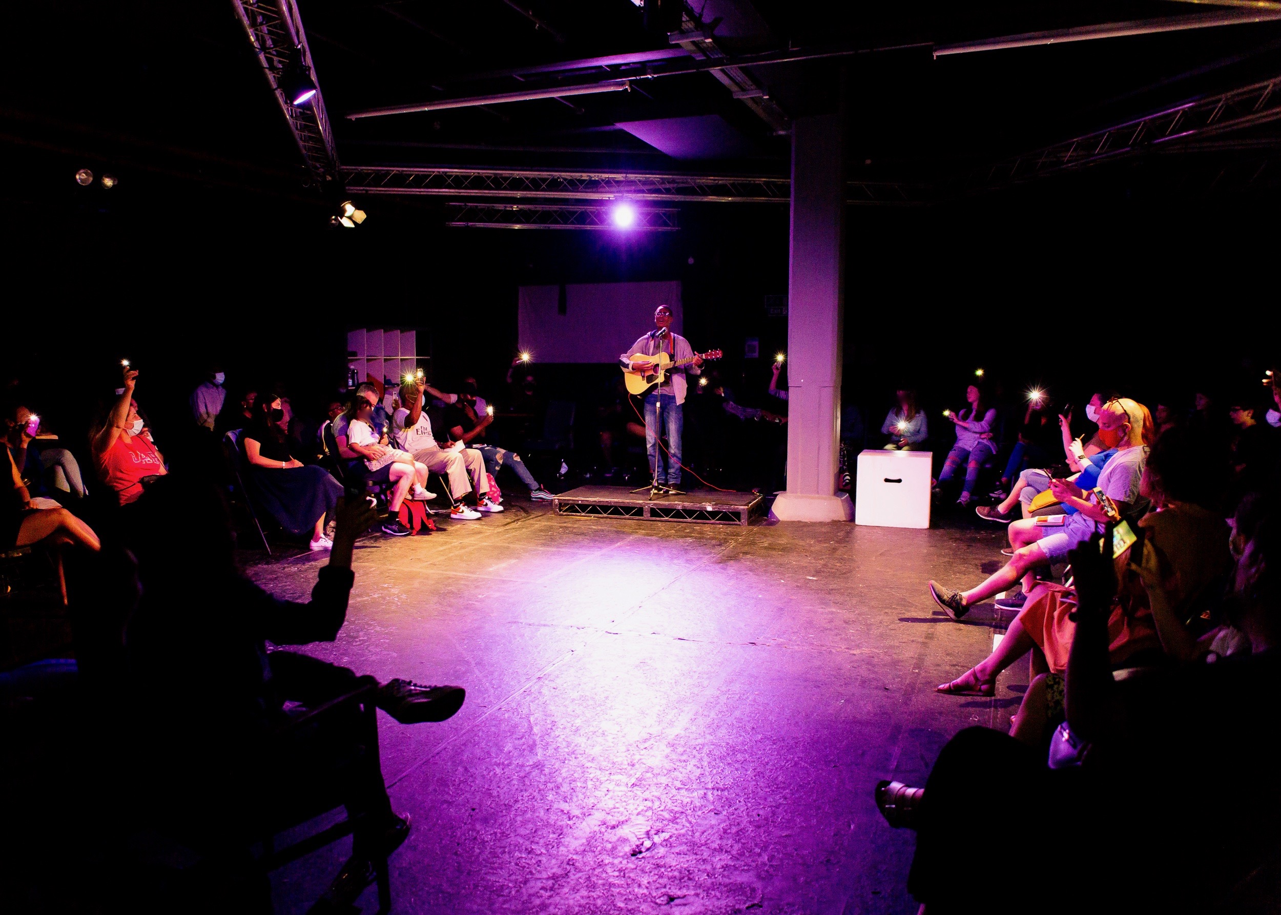 Intimate McQueens Theatre performance with spotlight, ideal for acoustic nights and storytelling.