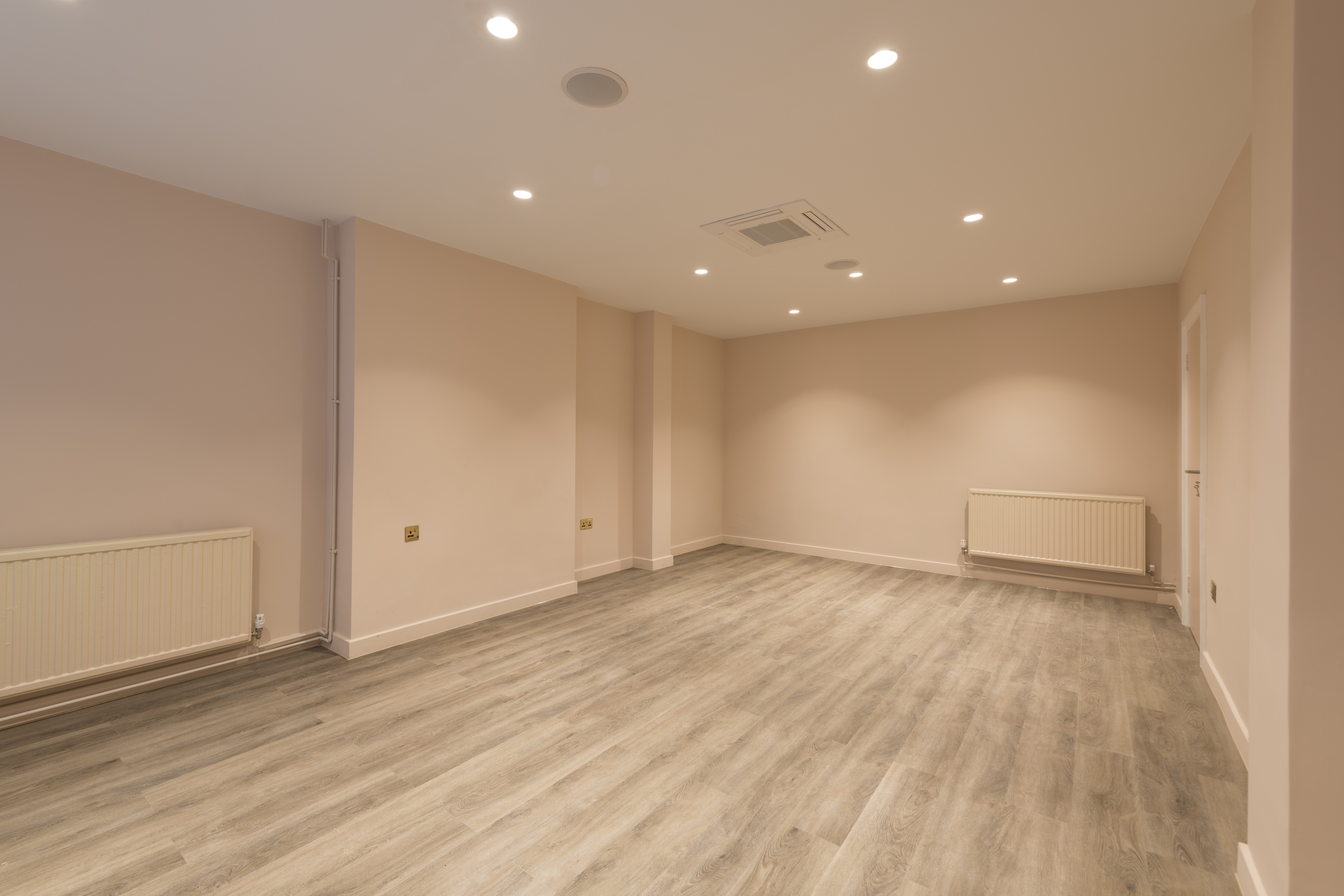 Versatile blank meeting space with bright lighting for workshops and gatherings.