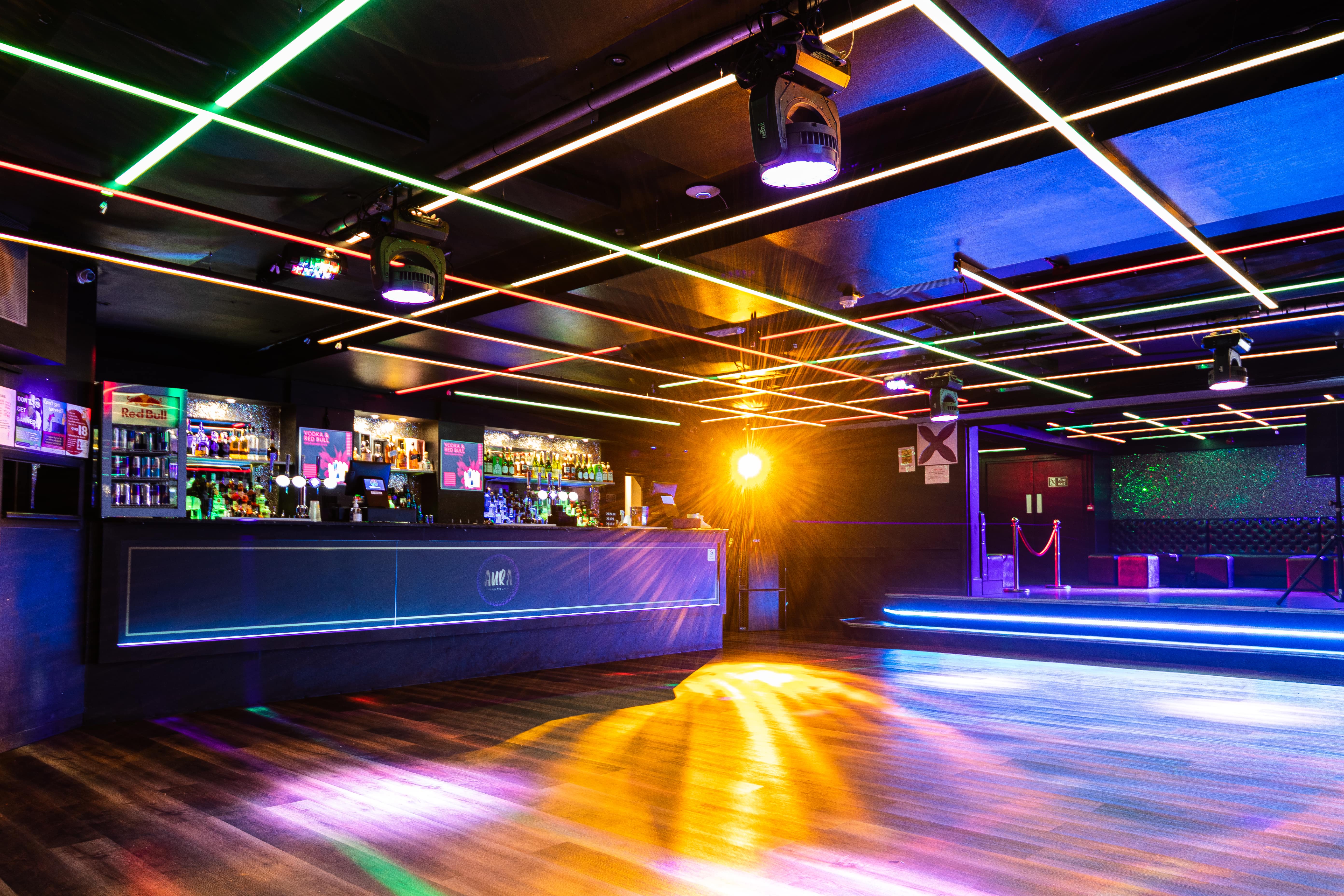 Vibrant event space in Aura Tunbridge Wells with sleek bar and dynamic lighting for parties.
