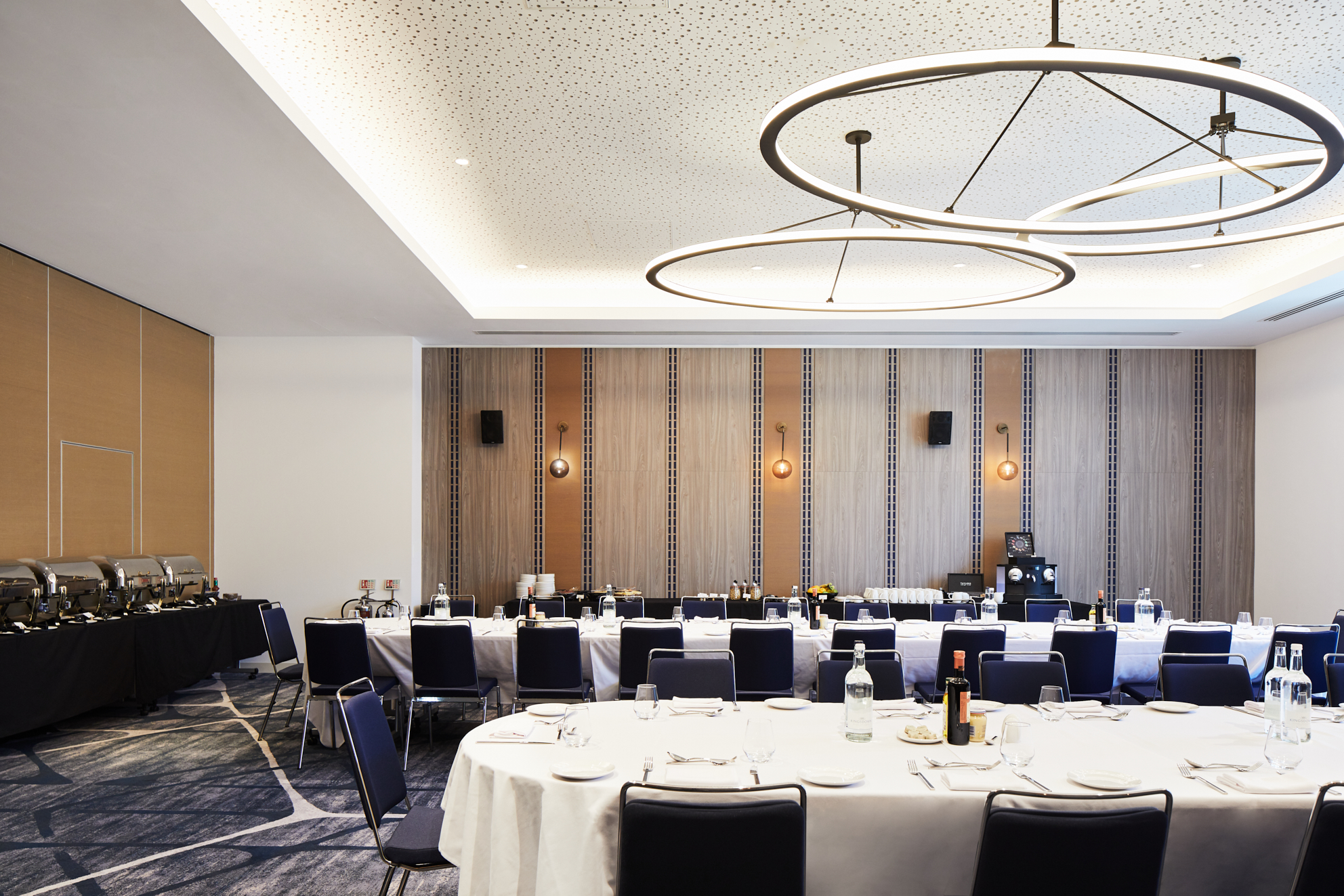 Hyatt Regency Manchester's Lewis Room, elegant meeting space with round tables and catering setup.