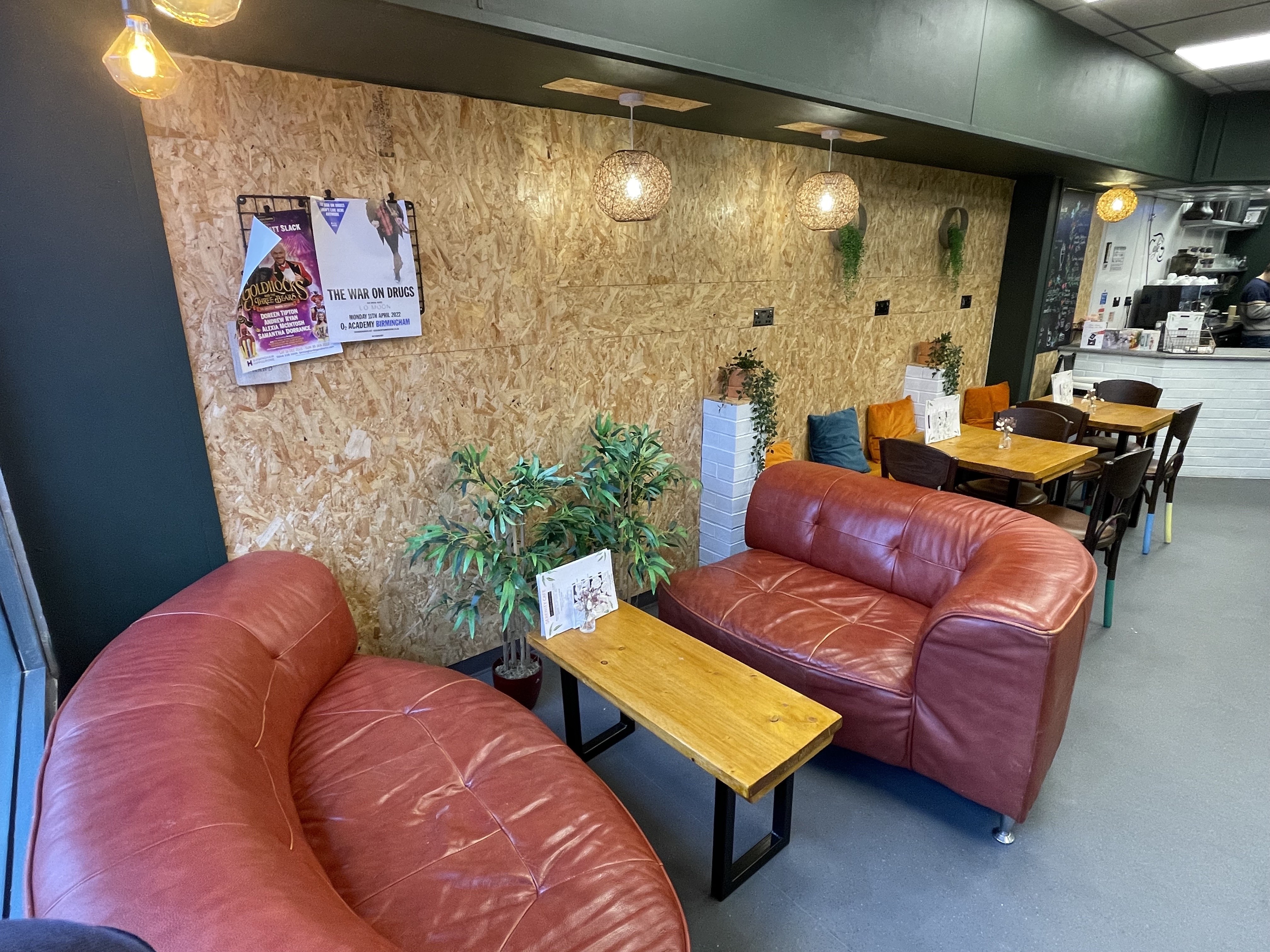 Cozy meeting space at Serenity Cafe with leather sofas, ideal for gatherings and brainstorming.